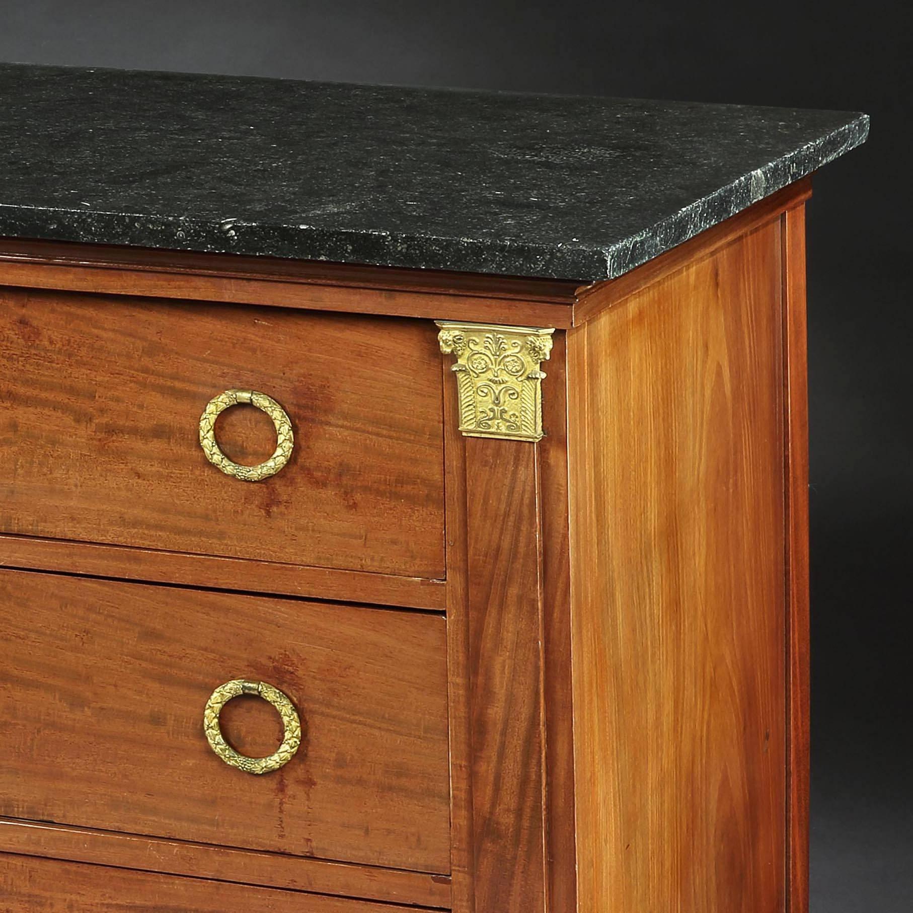 A fine early 19th century plum pudding mahogany commode with gilded Corinthian capitals, graduated drawers, all supported on ebonised paw feet