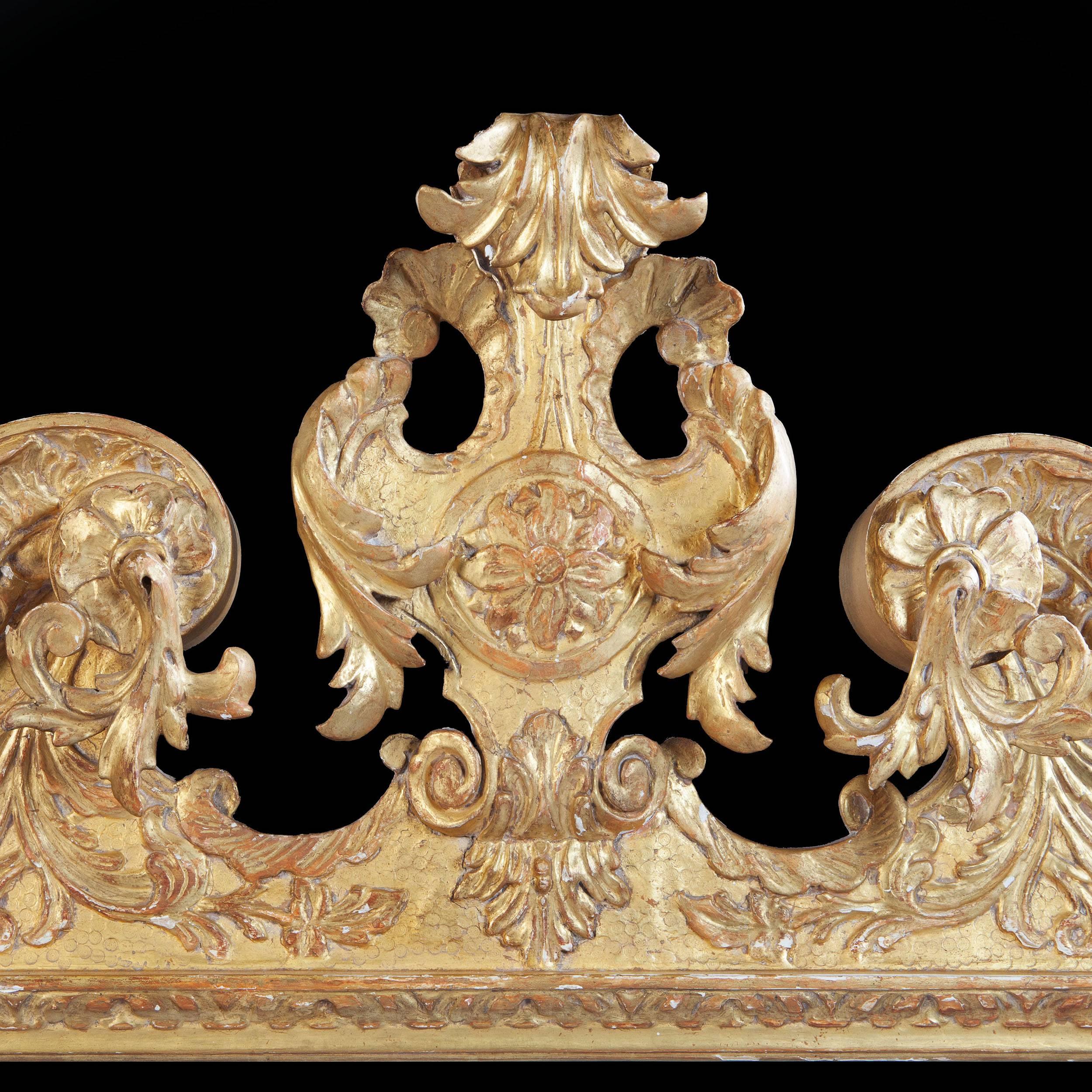 An early 18th century gilt gesso pier mirror, with architectural pediment, punched foliate decoration throughout and scrolling acanthus leaves to the sides.