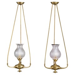 A Pair of Unusual Edwardian Brass Hanging Oil Lamps with Glass Hurricane Shades