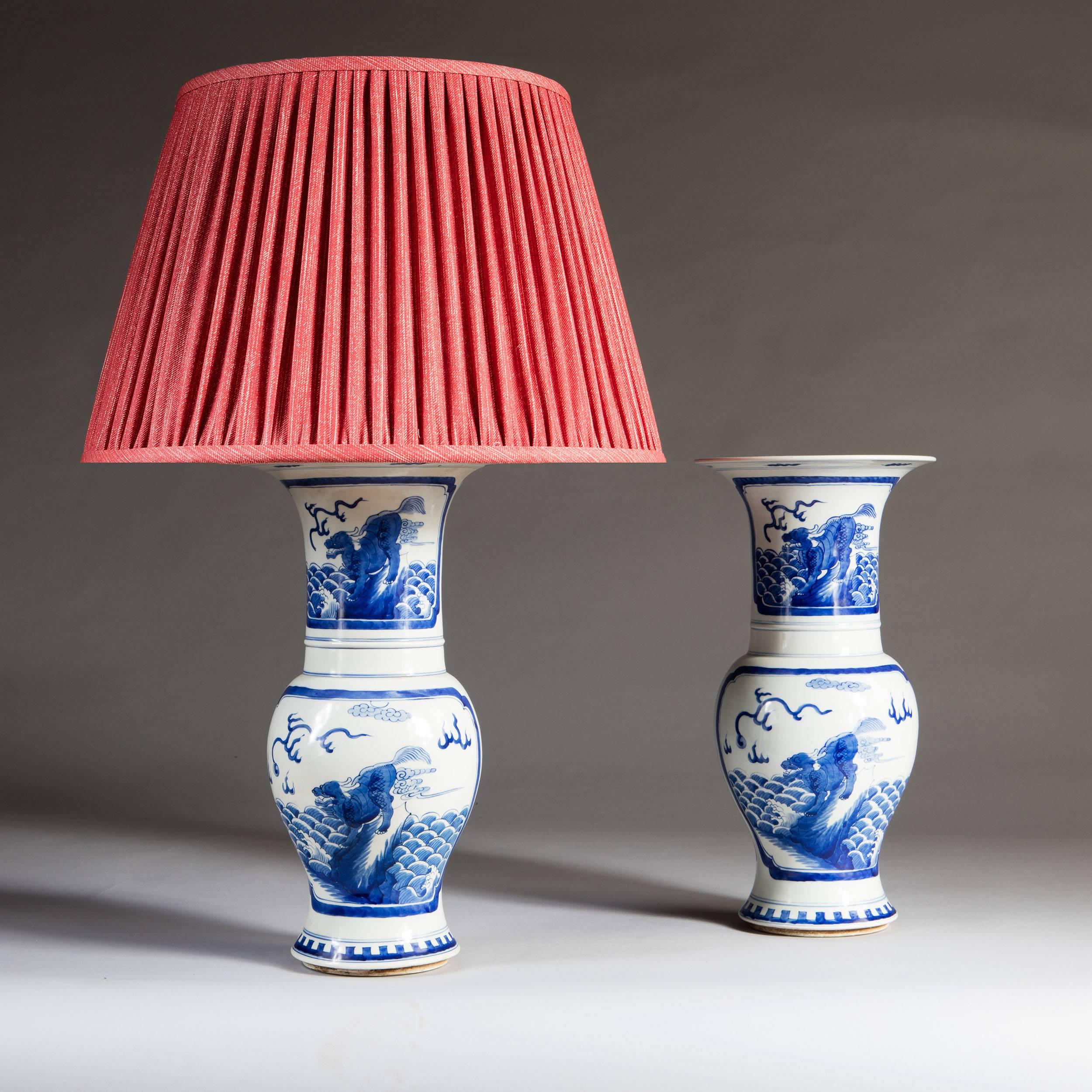 A pair of 20th century Chinese blue and white trumpet vases, decorated with cartouches depicting dragrons.

Please note: Lampshades not included.

Currently wired for the UK. Please enquire for rewiring services. 