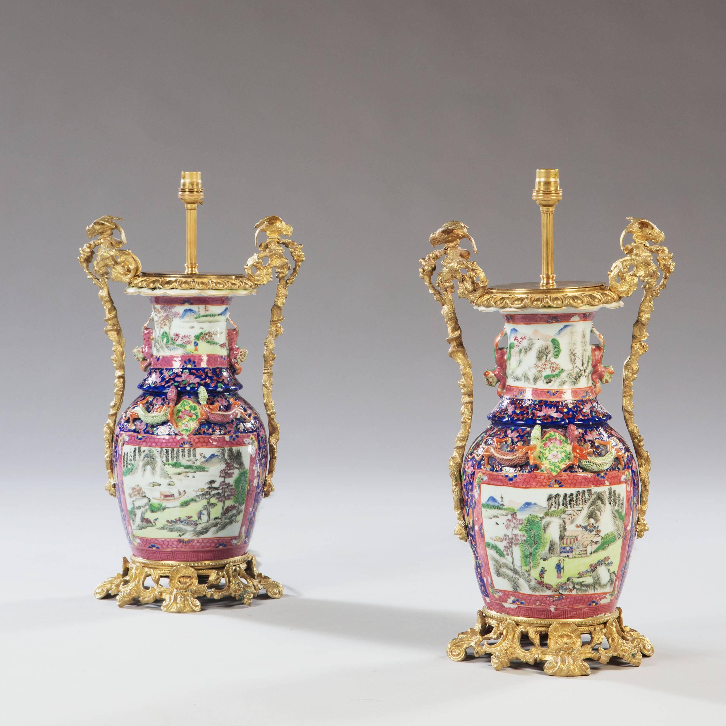 A fine pair of mid-19th century famille rose vases, painted with scenes of landscapes, now mounted with extravagent ormolu mounts.