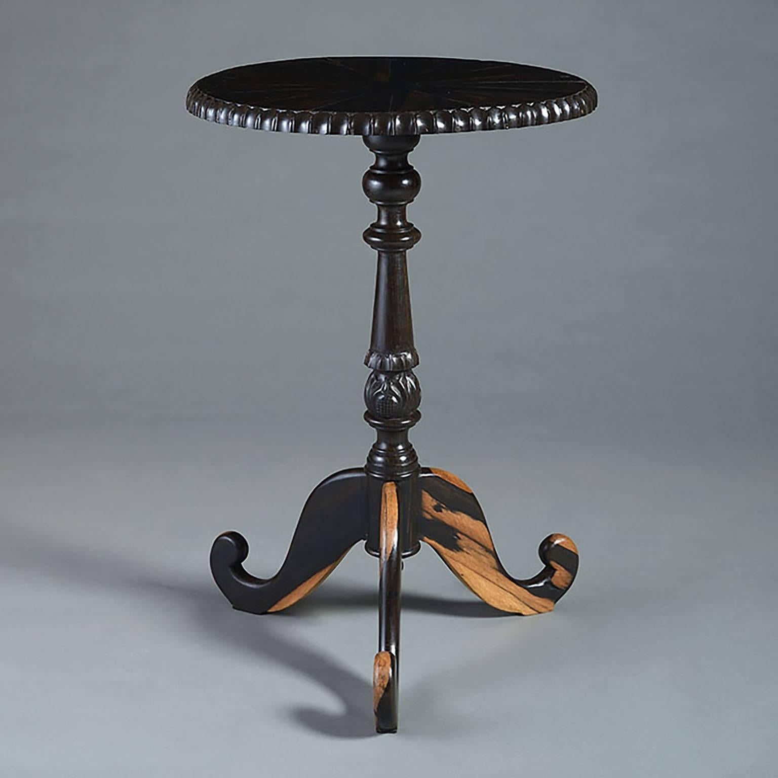 A pair of 20th century ebony occasional tables with carved pedestal and tripod bases.