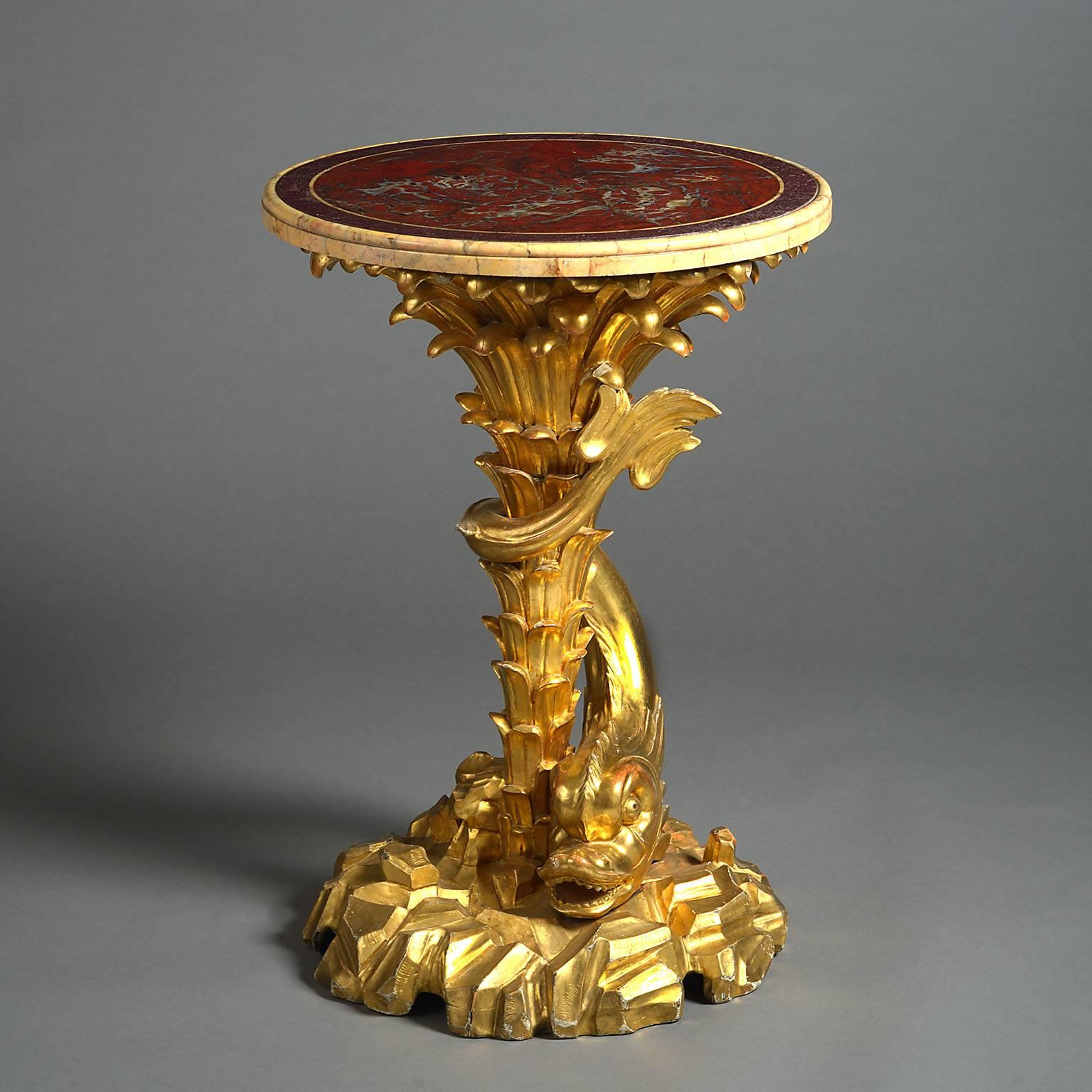 A late 19th century giltwood dolphin table with carved palm fronds to the pedestal, surmounted by a red marble top.