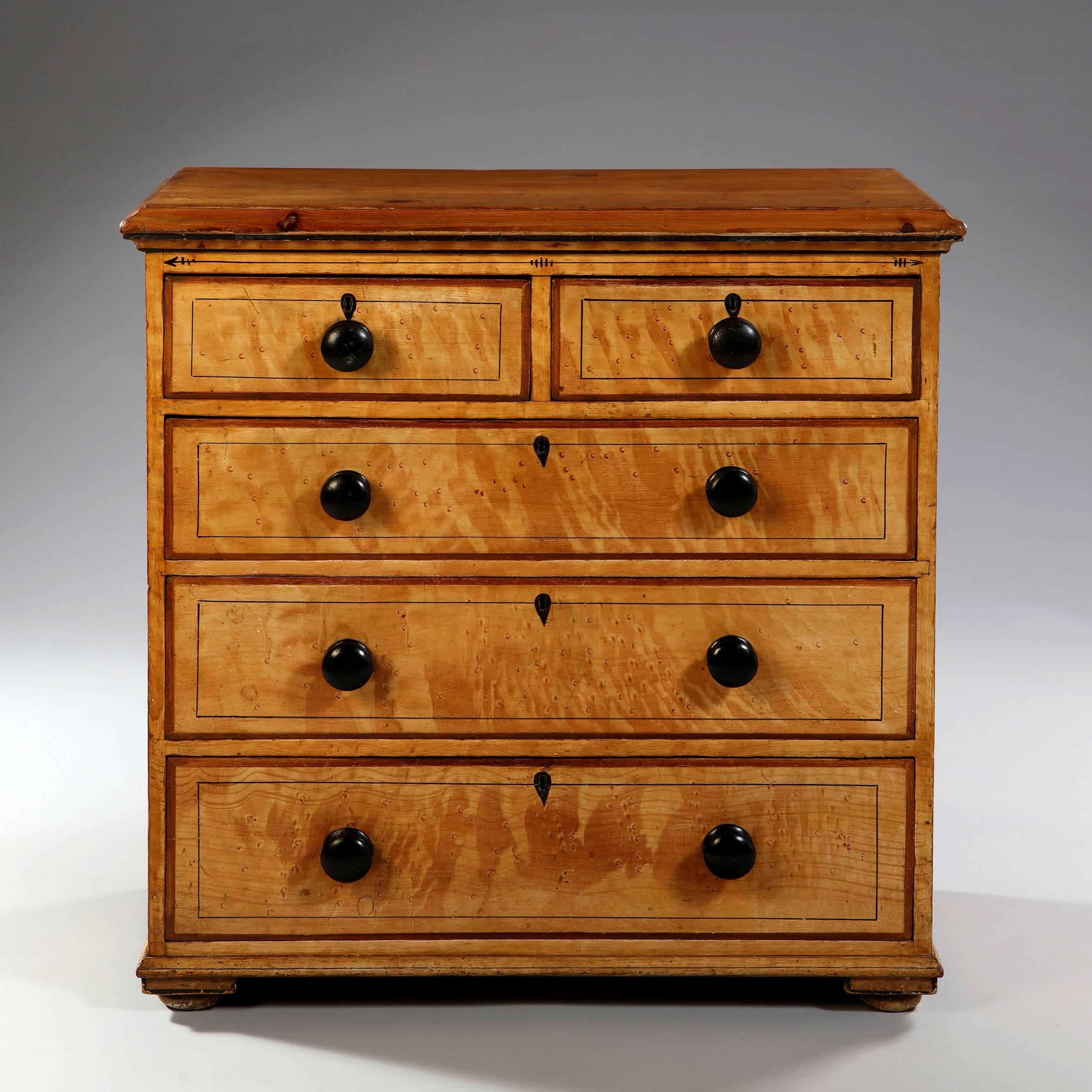 An early 19th century English chest of drawers, painted to simulate bamboo. Opening with five drawers and all supported on bun feet. The paint to the top having been worn away through usage.