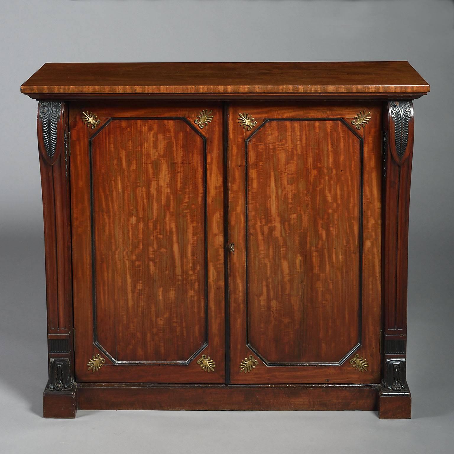 A fine Regency early 19th century mahogany side cabinet, with two doors and vitruvian scrolled uprights and brass anthemions.