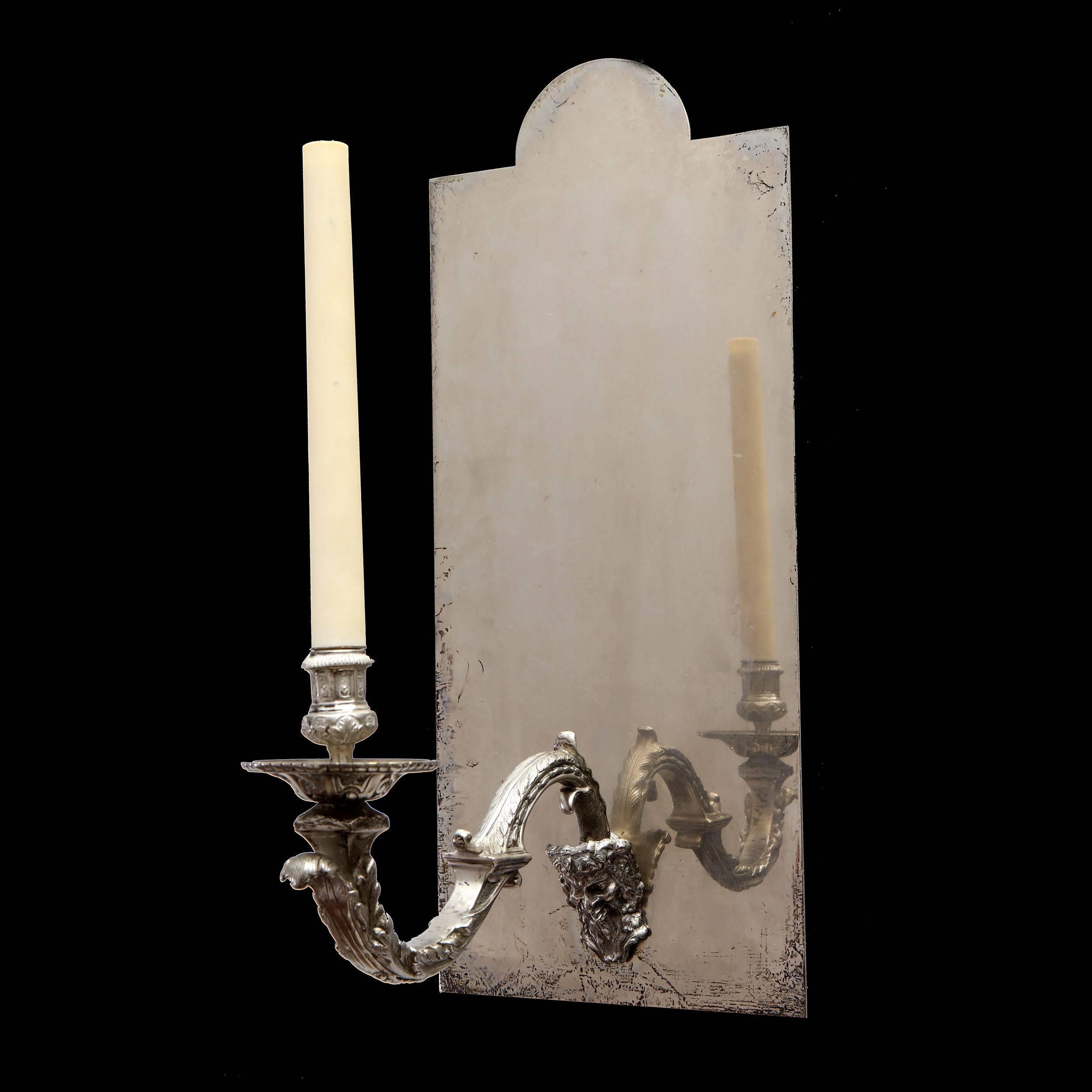 A fine pair of silver sconces, the arms modelled with a Satyr mask mounted on mirrored back plates.