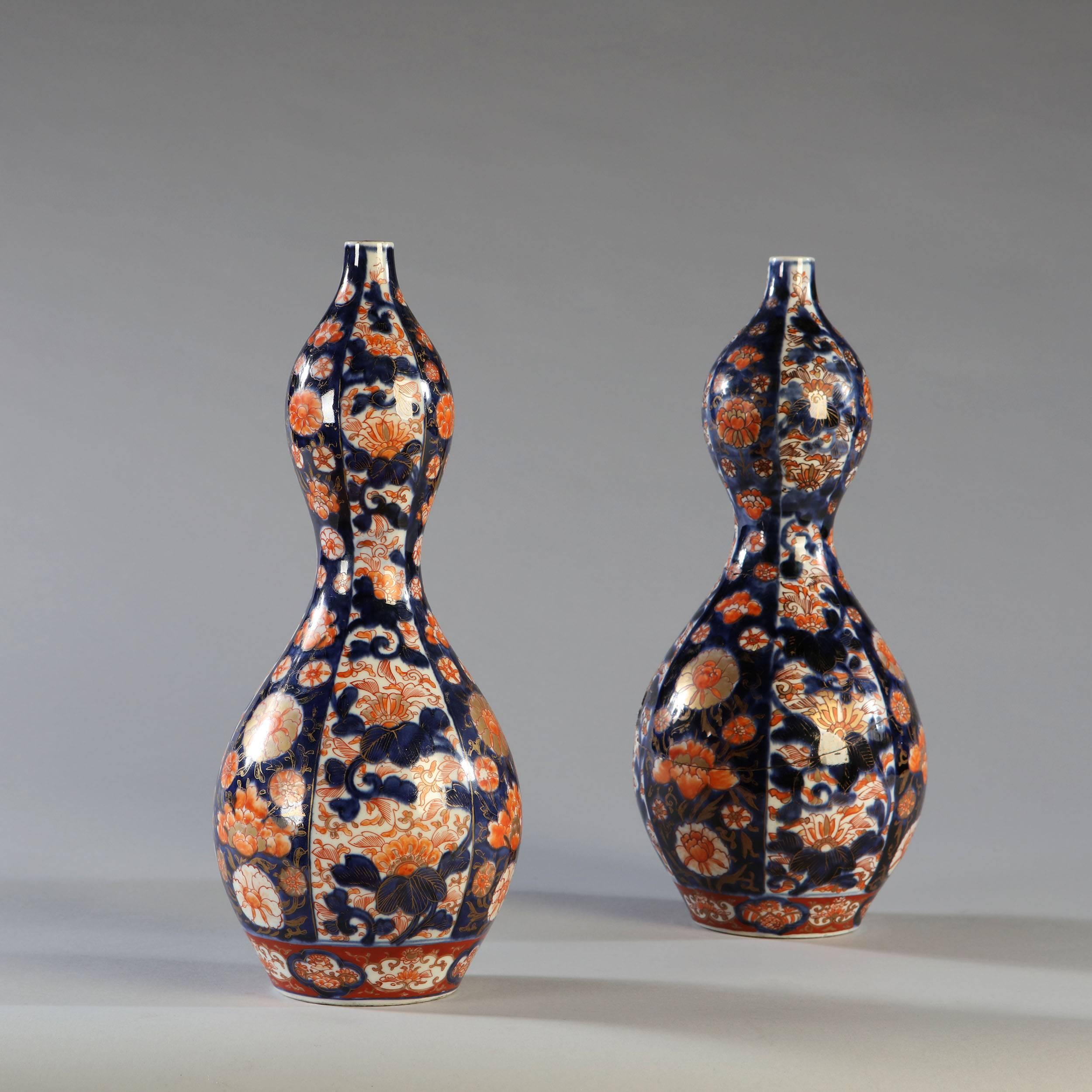 A pair of early 19th century Imari double gourd vases, with floral motifs, now converted as lamps. Restored.