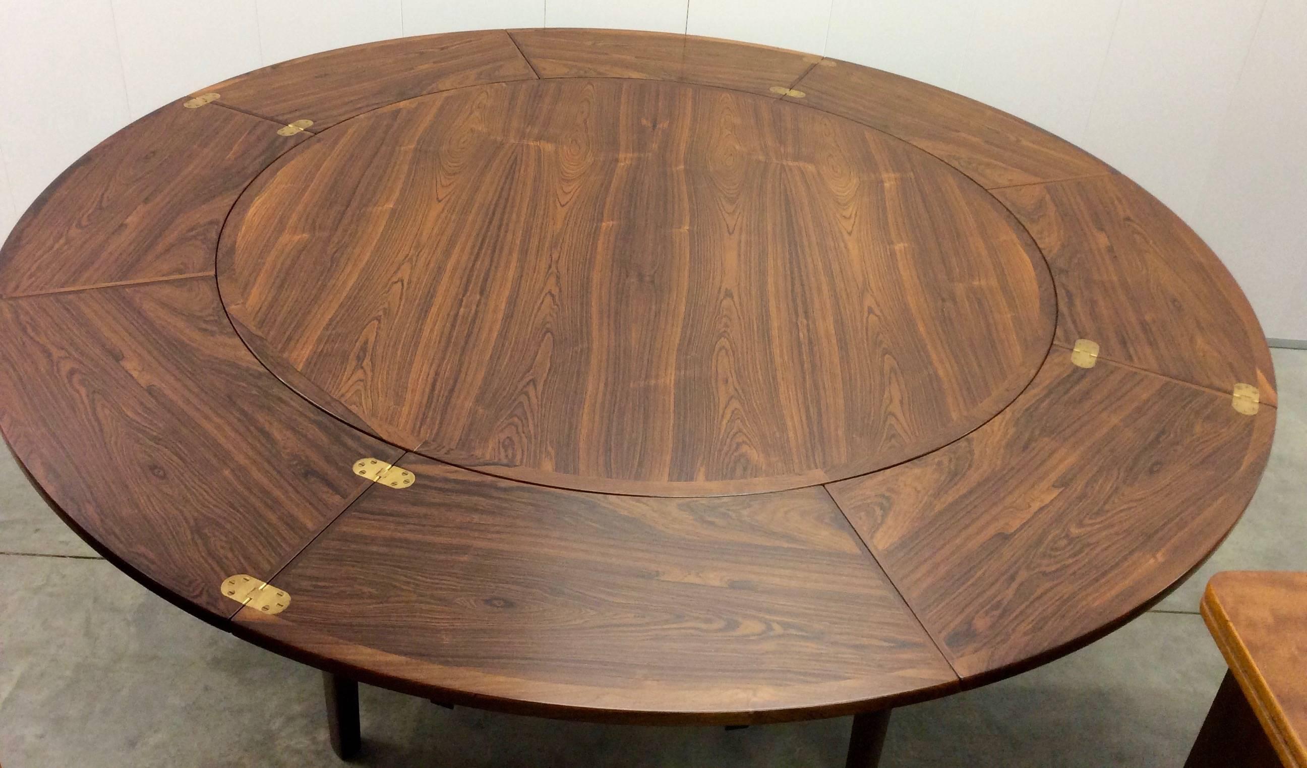 Mid-Century design at its best designed and produced by Svend Dyrlund.
Stunning rosewood flip flap dining table.
This extendable dining table has four leaves which pull out and flip over to rest on each other to form an outer ring around the main