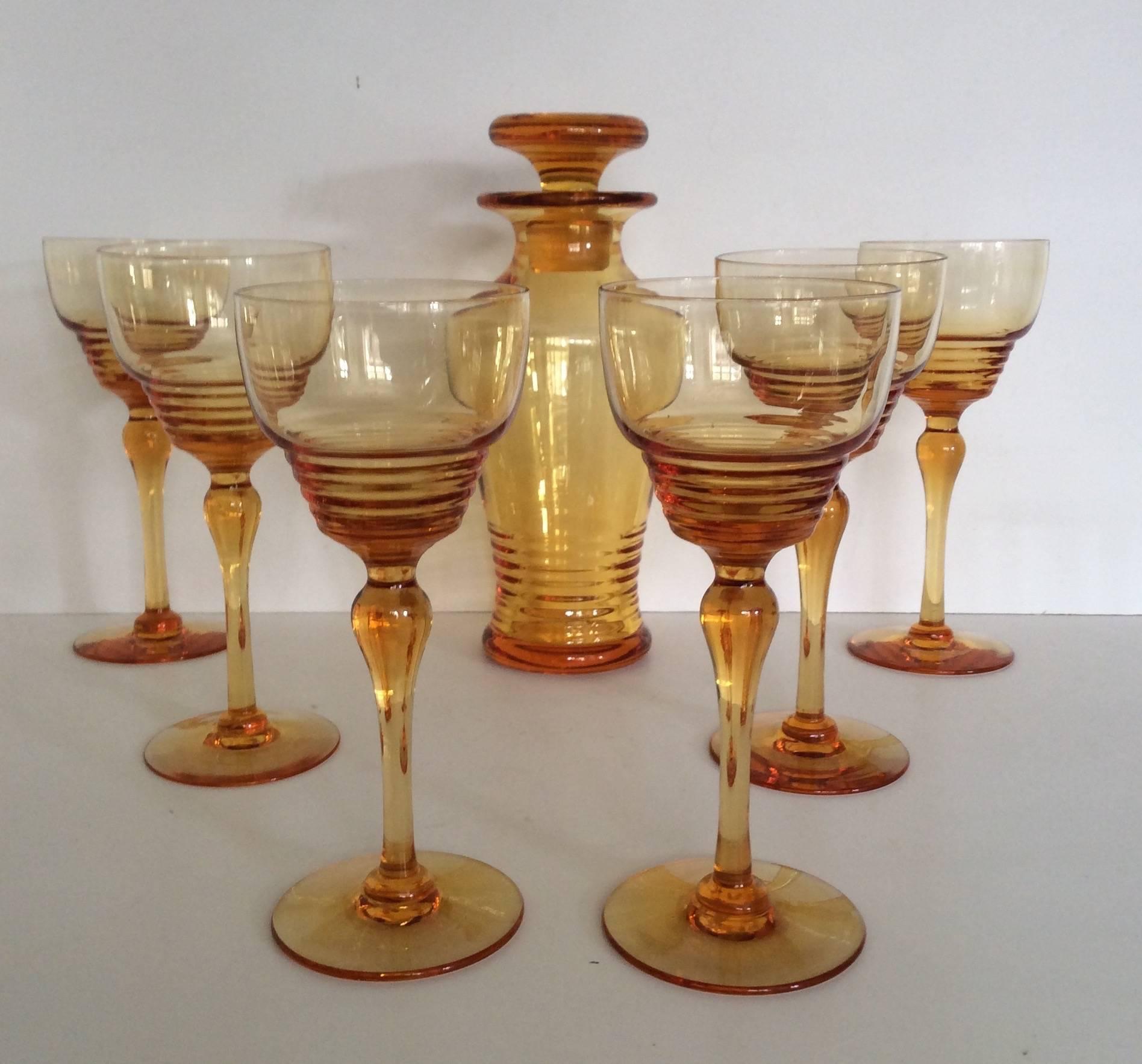 A set of Art Deco Hock glasses and decanter.
Stuart crystal Art Deco amber glass set, six Hock glasses with matching decanter.
British, circa 1930.
Measures: Glasses 17.5 cm height, 7.5 cm diameter.
Decanter 22 cm height, 10 cm diameter.