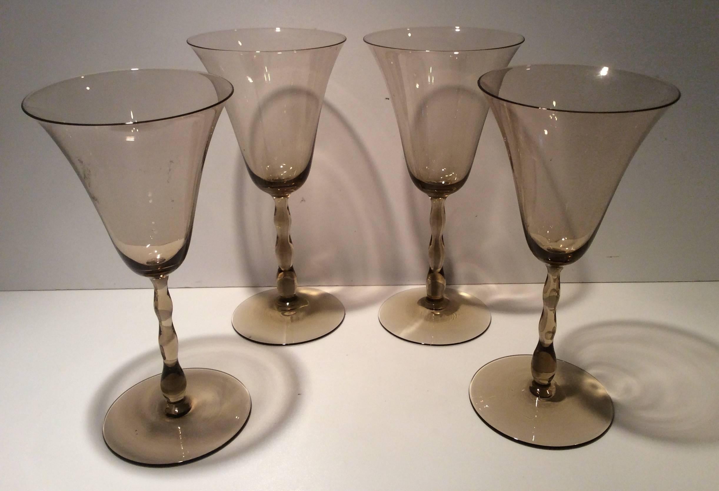 A suite of glasses smokey grey in the Astrid design.
Produced by Orrefors Designed by Simon Gate.
One tall decanter with feather finial 38 cm H, 10 cm D.
Four wine glasses 16.5 cm H 8 cm D at the top
Four liqueur Glasses 14 cm H 6 cm D at the