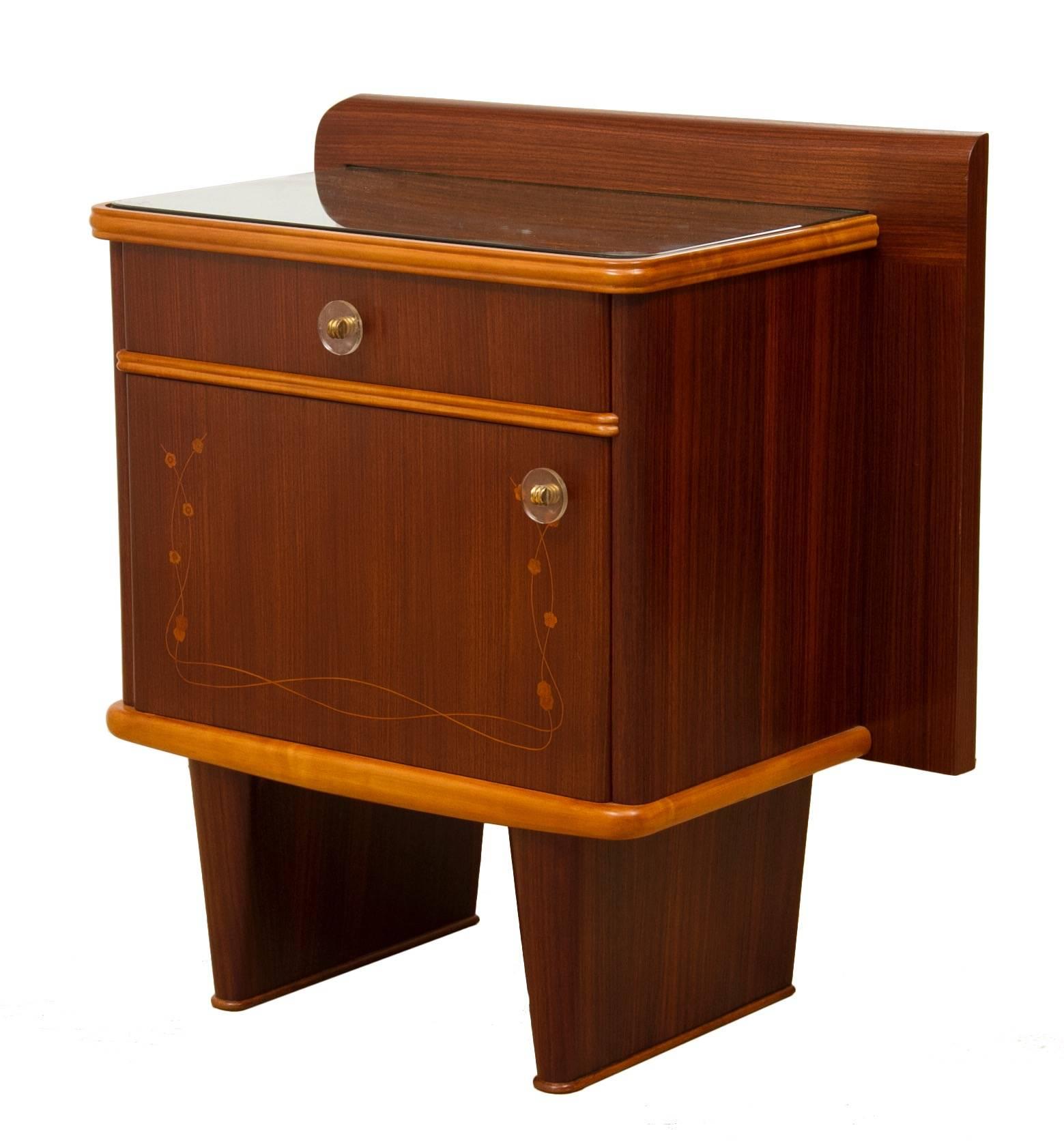 A pair of Italian nightstands.
Beautiful Mid-Century bedside cabinets with inlaid floral decoration.
Walnut with ash beading and mirror tops.
Measures: 70 cm H at the back 63 cm H 63 cm W at the back 53 W 34 D.
Designed by Mario Ballini.
Design