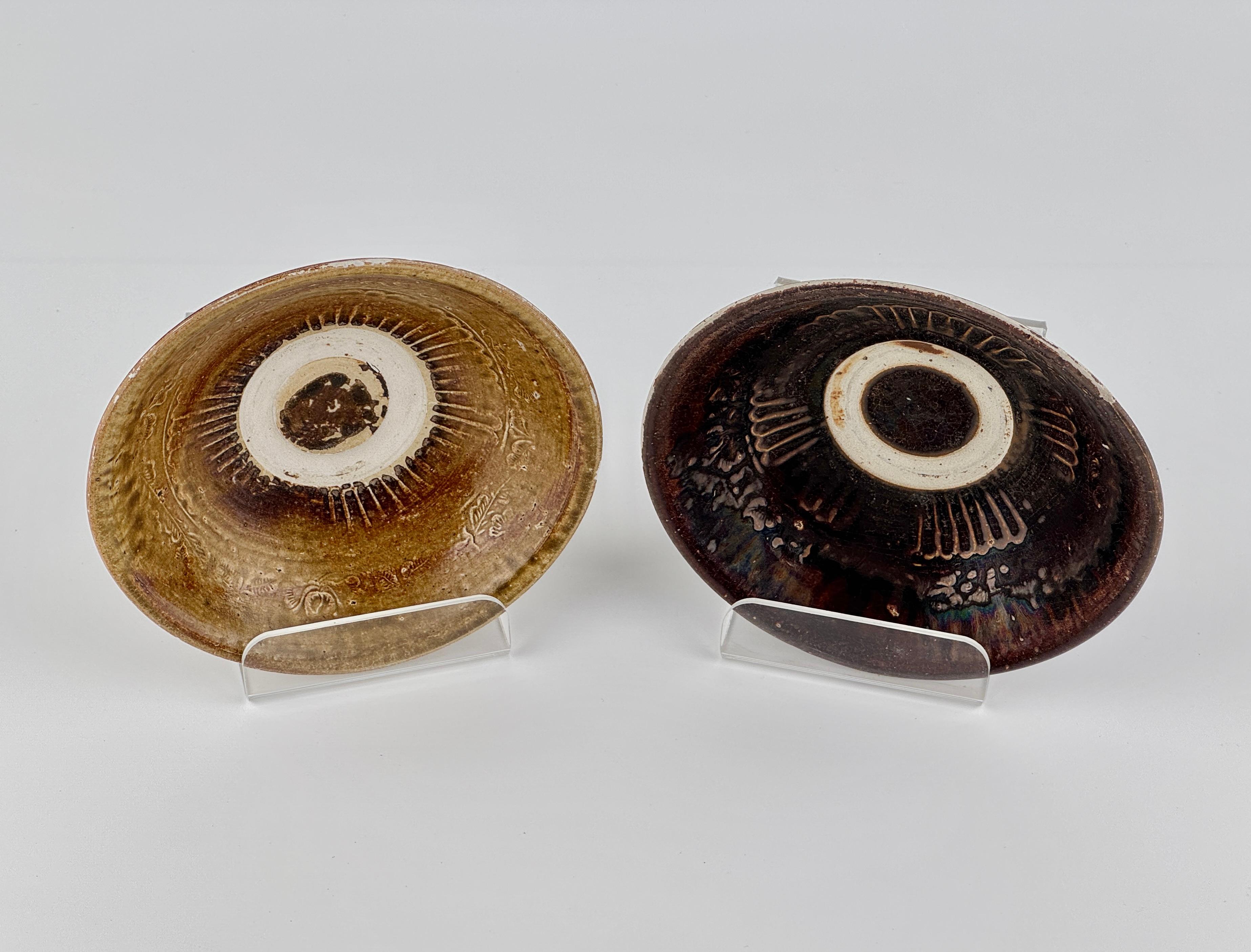 Questa coppia di ciotole in gres Annamese, finemente abbinata, esemplifica la raffinata arte ceramica del Đại Việt (Vietnam medievale) durante il XIV-XV secolo. Ogni ciotola è delicatamente invasata con lati delicatamente svasati e un piede