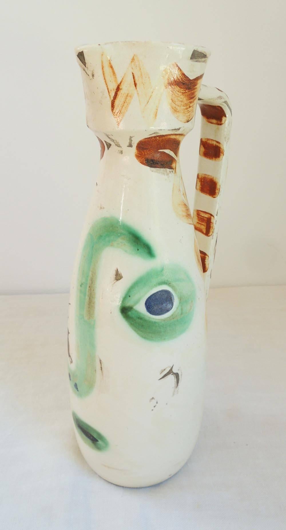 Part of the series Pablo Picasso did painting faces on common kitchen ceramic objects from 1947-1971. This pitcher is dated 9.1.69, incised below the handle.
This piece is number 380 of a series of 500. The imperfections in the glaze are