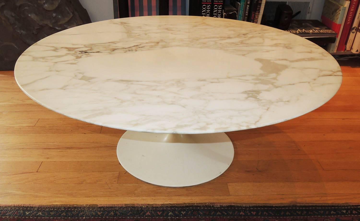Eero Saarinen's Tulip cocktail table for Knoll.  Round Carrara marble top with reverse bevelled edge sits on top of a white enameled metal pedestal base. Original Knoll label.