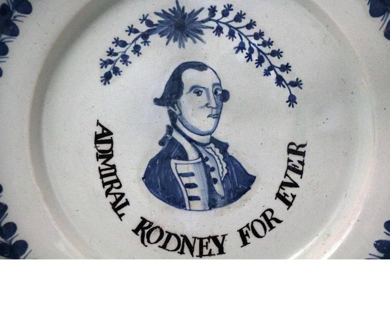 A more than rare London delftware pottery plate with a portrait of Admiral Rodney, late 18th century. 
The figure is surrounded by a starburst and garland of flowers over his head and beneath in capitals the legend 