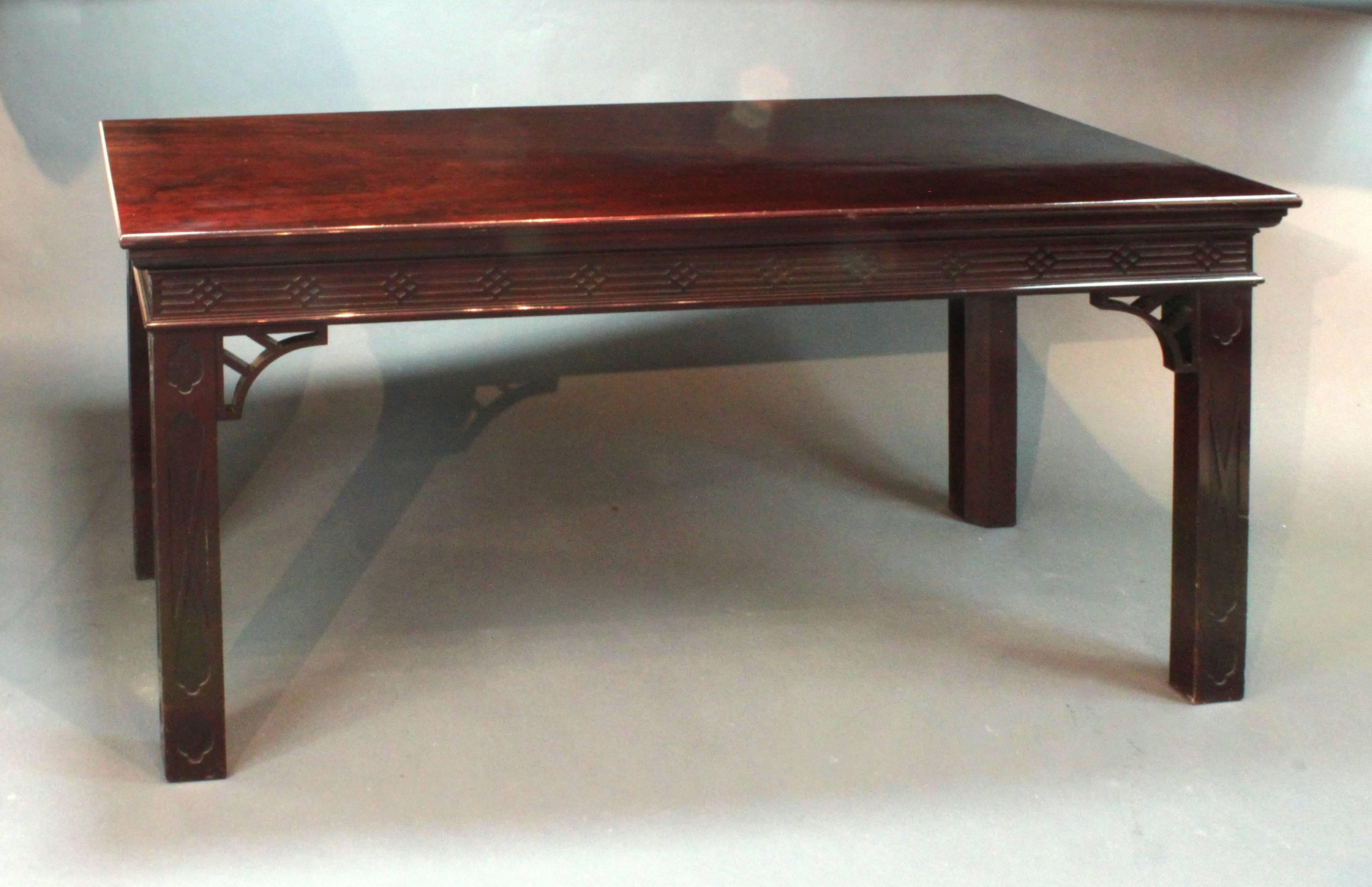 A Chippendale side table/centre table by Butler of Dublin. The top in figured mahogany with solid mahogany legs and frieze; finished on all four sides with applied blind fret to the frieze and legs and with the original pierced brackets. Irish