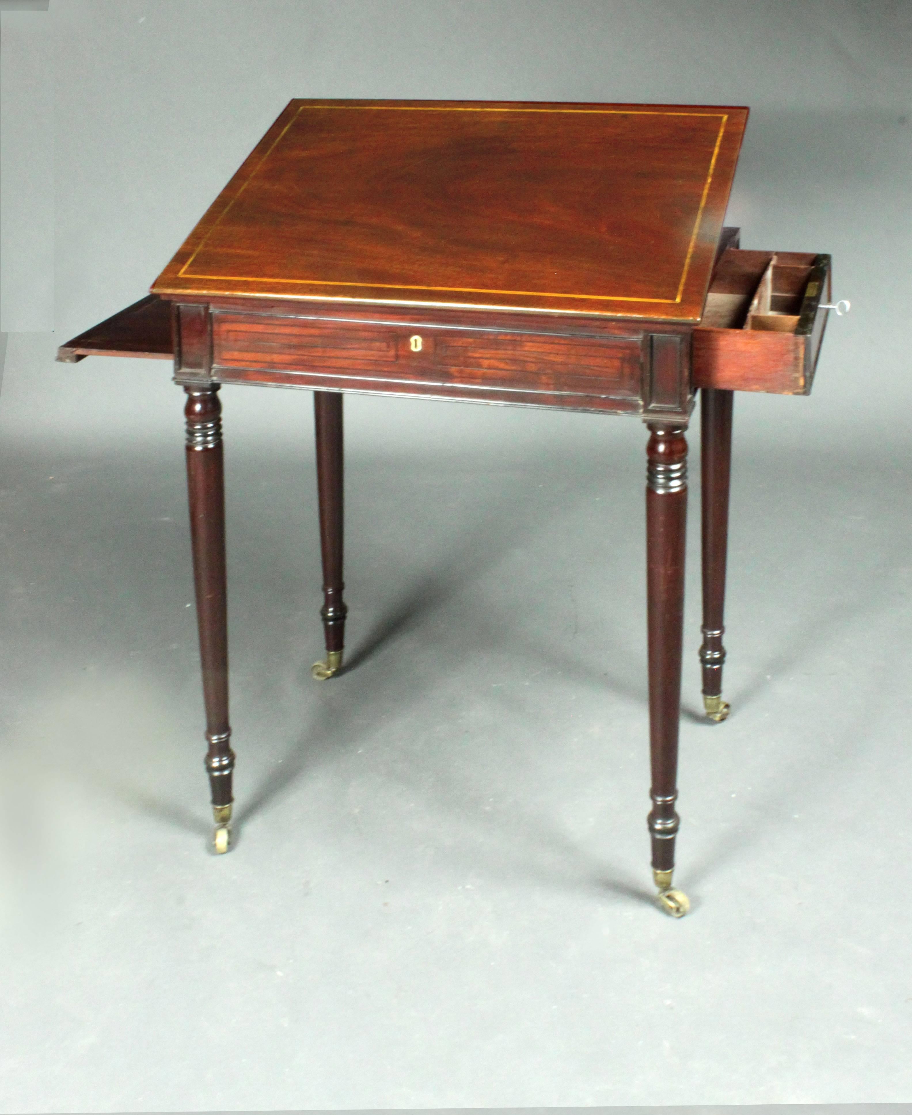 A lovely quality small Regency draftsman's table in mahogany with Greek key ebony inlay; handsomely finished with three false drawers and one real, fitted drawer, the framed top with stay and ratchet; elegant slim turned legs.

  