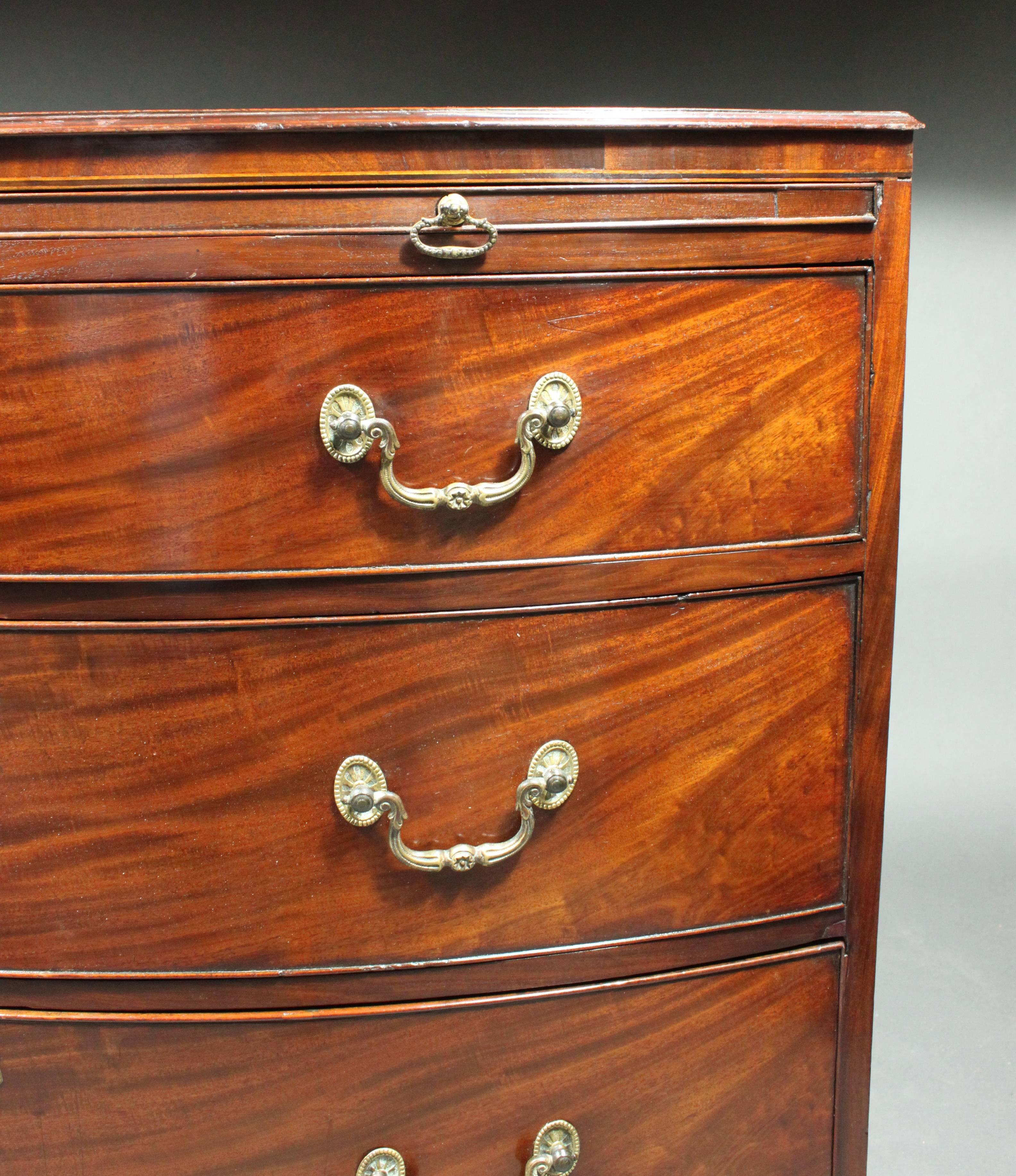 A fine George III bow-front chest in figured mahogany with box wood and ebony stringing; original cast swan-neck handles still retaining some of their gilt; oak lined drawers and panelled back.