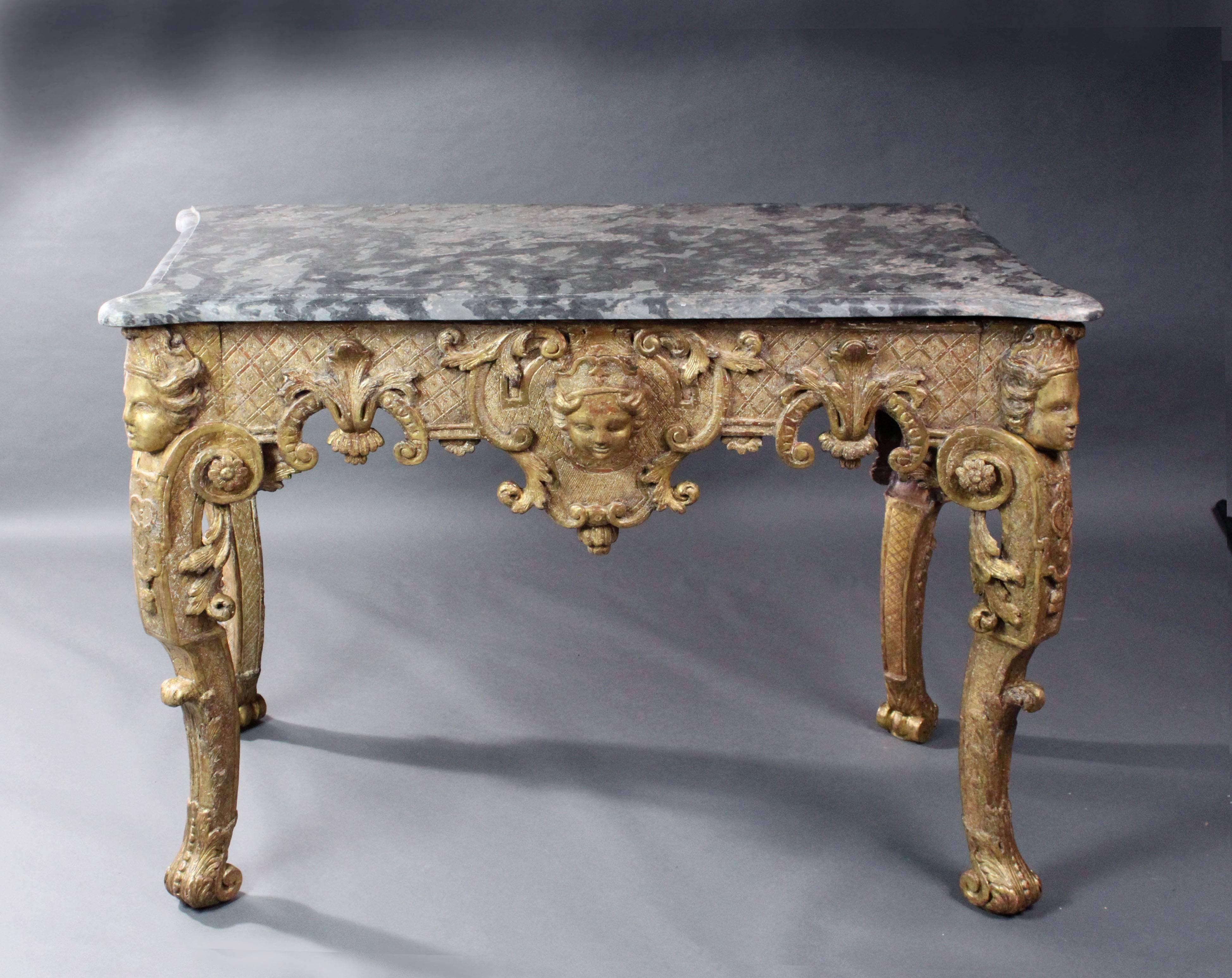 A fine late 17th-early 18th century Italian or French giltwood console table retaining much of its original gilding; supported on well carved caryatids with scroll feet; the frieze with carved acanthus leaves, Rococo scrolls and a carved mask on a