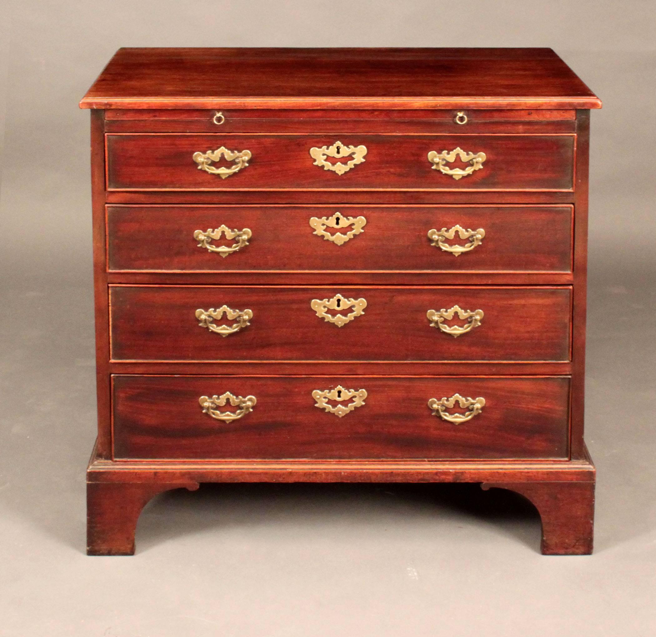George III small mahogany chest of drawers with original plate handles and brushing slide, the drawers oak lined; good color and patina.