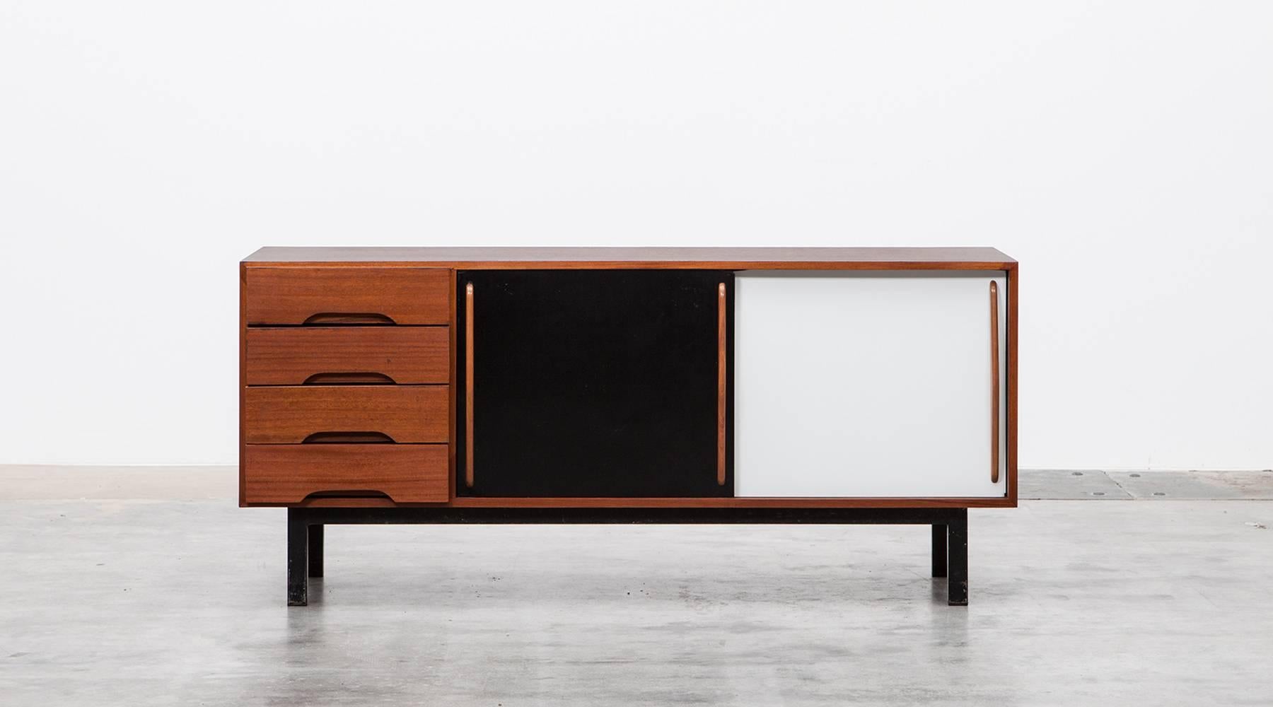 Beautiful and really rare Charlotte Perriand sideboard edited by Steph Simon. This piece is made out of mahogany and comes with four drawers and two laminate sliding doors. The sideboard is in very good original condition with patina, reworked by