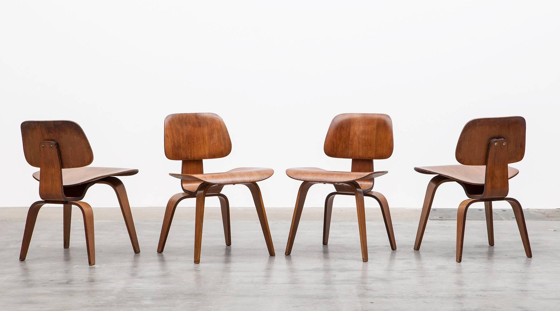 Beautiful und really rare matching set of four DCW chairs designed by famous American Charles & Ray Eames. These chairs are all early examples and made out of plywood in walnut and comes in perfect condition with beautiful patina. Manufactured by