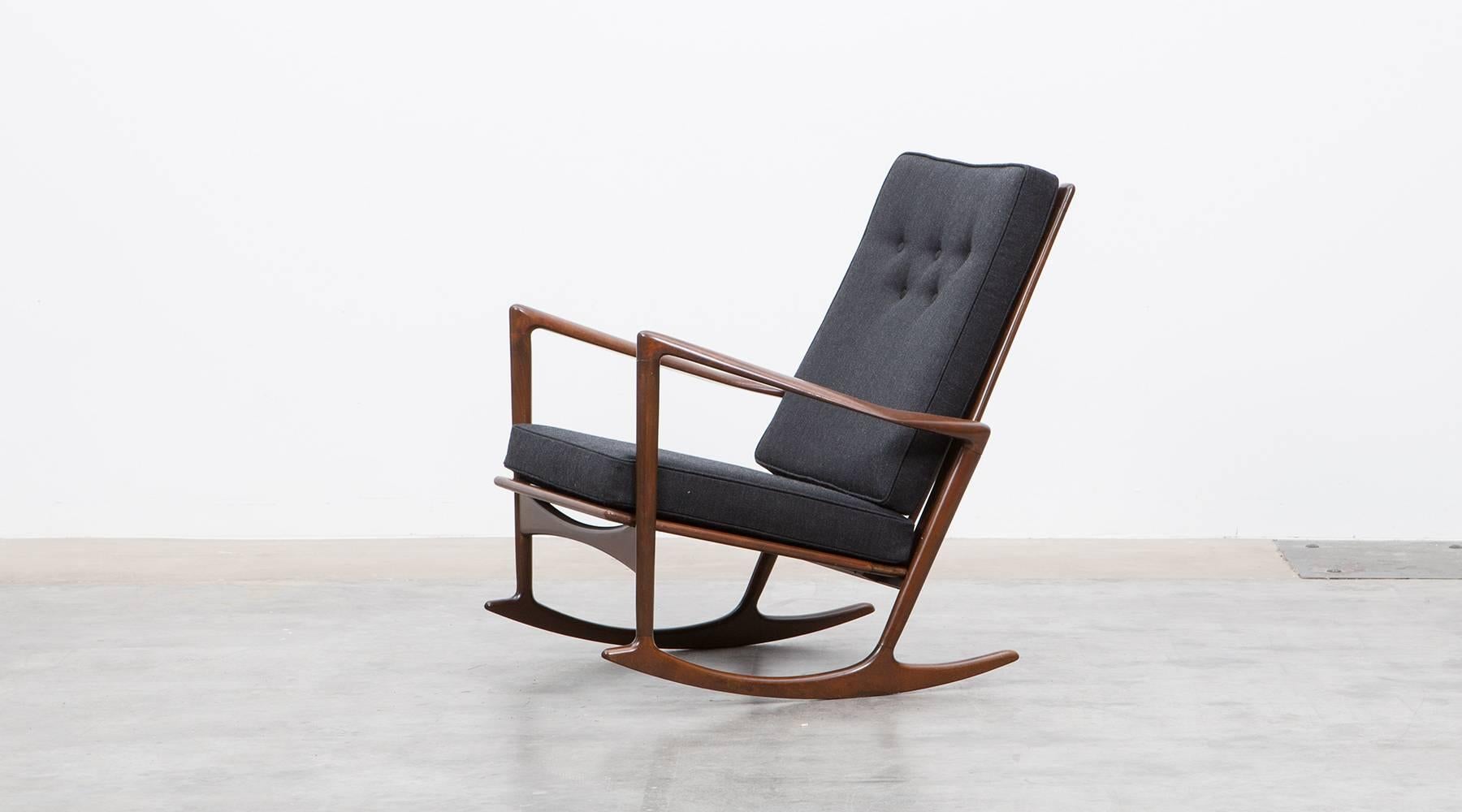 Rocking chair with brown walnut frame designed by famous Ib Kofod-Larsen.
This lounge chair comes with comfortable seating area which are recently new upholstered with high-quality fabric. The chair is in very good vintage condition from 1962.