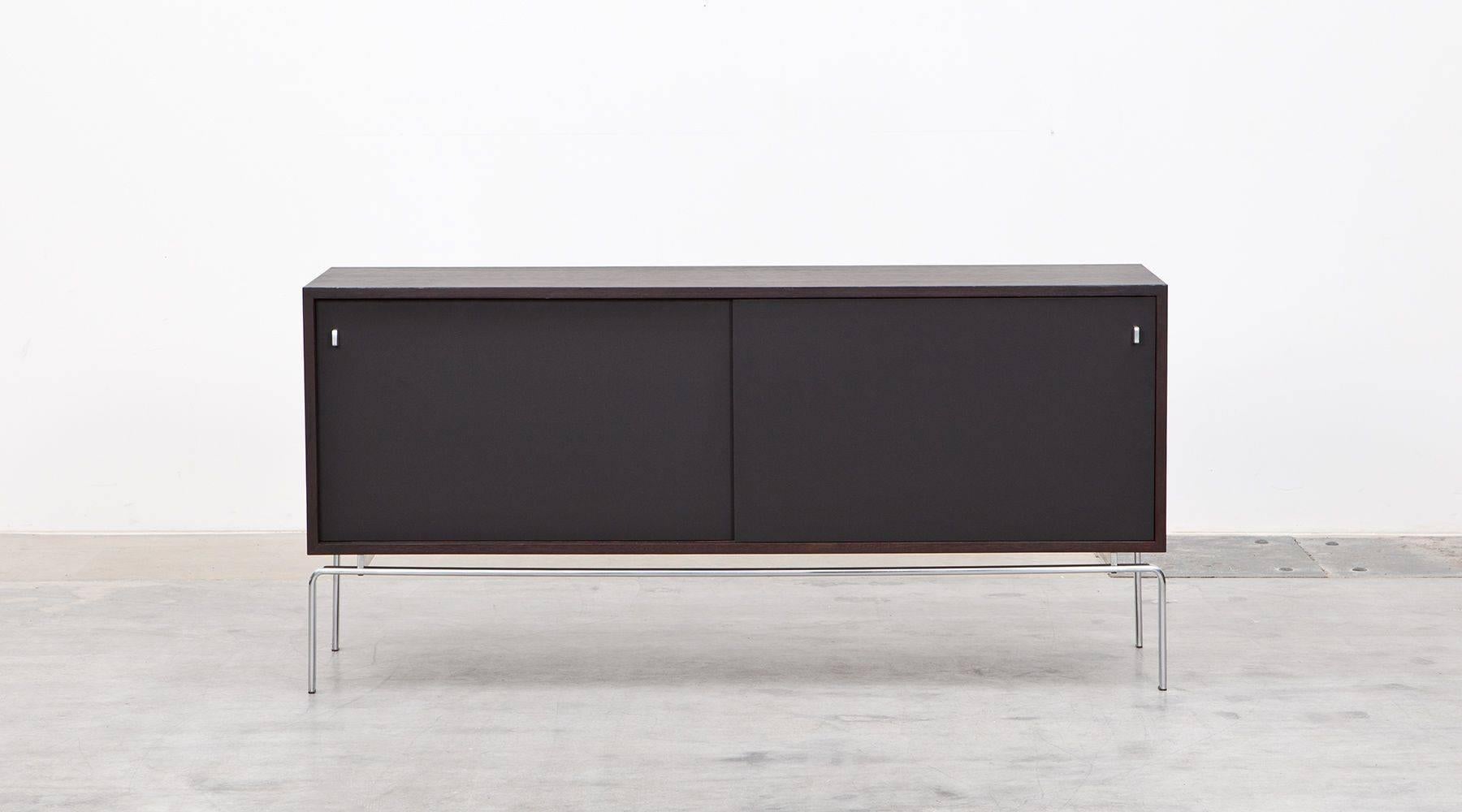 A wonderful pure sideboard in wenge stained designed by Preben Fabricius and Jørgen Kastholm. It offers a lot of storage space with many practical compartments and four drawers inside. The two sliding doors are laminated; the feet are made from