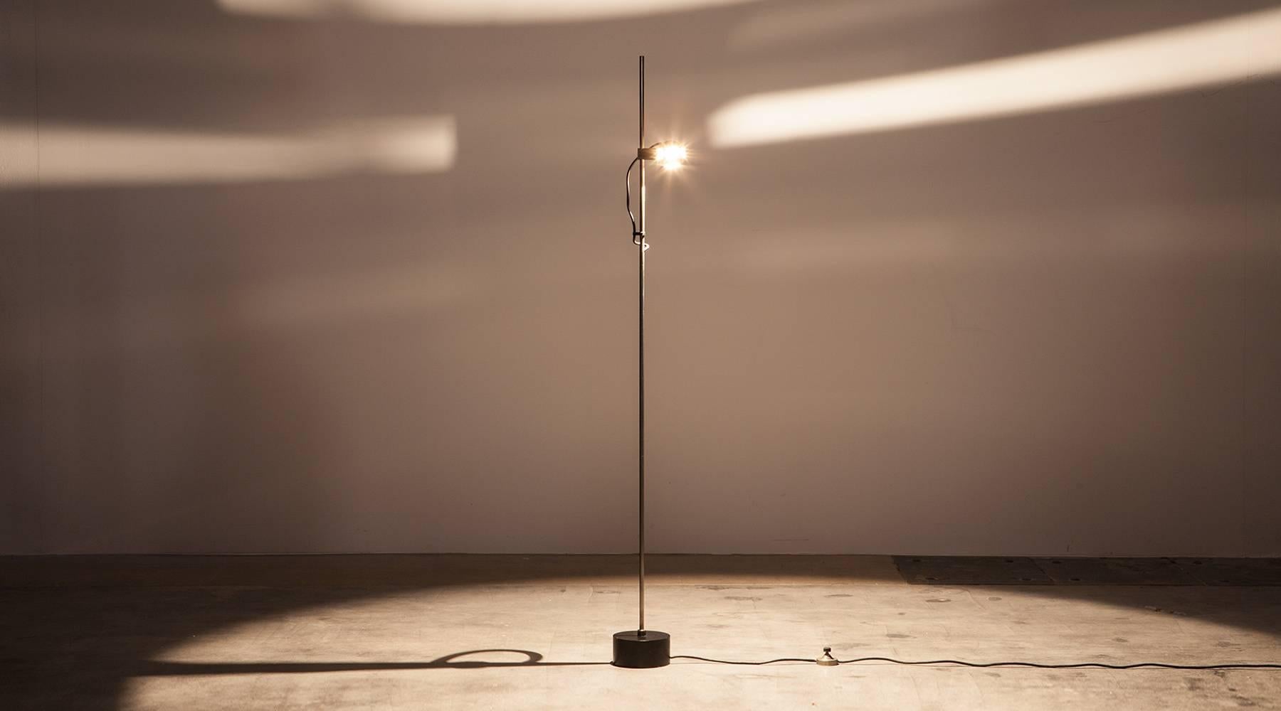 This minimalistic, exceptional Floor lamp is designed by Angelo Lelli. The metal eye ball lamp sits in a magnetic mount, allowing for easy adjustment of lighting. The slim stand rests on a solid foot. Manufactured by Arredoluce. 

Lelli is an
