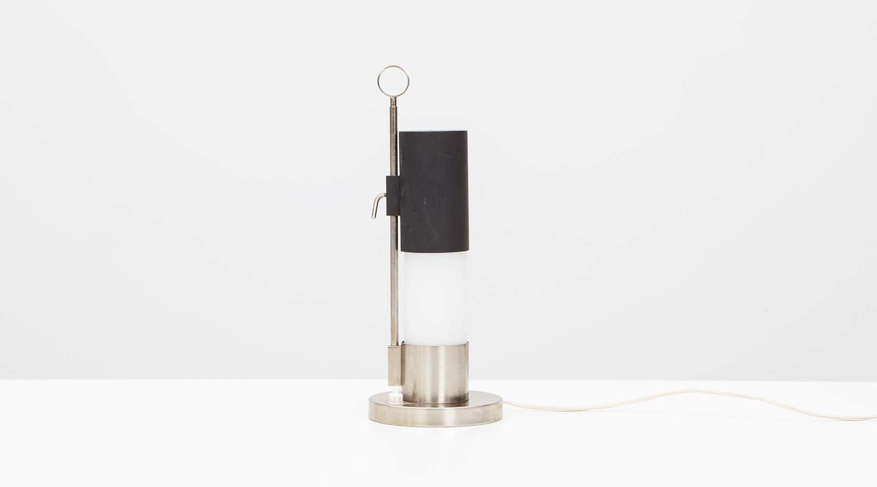Adjustable table lamp with constructivist form is attributed to Italian designer Angelo Lelli. The cylindrical steel table lamp with sliding cover-bulb on a small steel vertical arm on a circular steel base. Manufactured by Arredoluce. 

Arredoluce