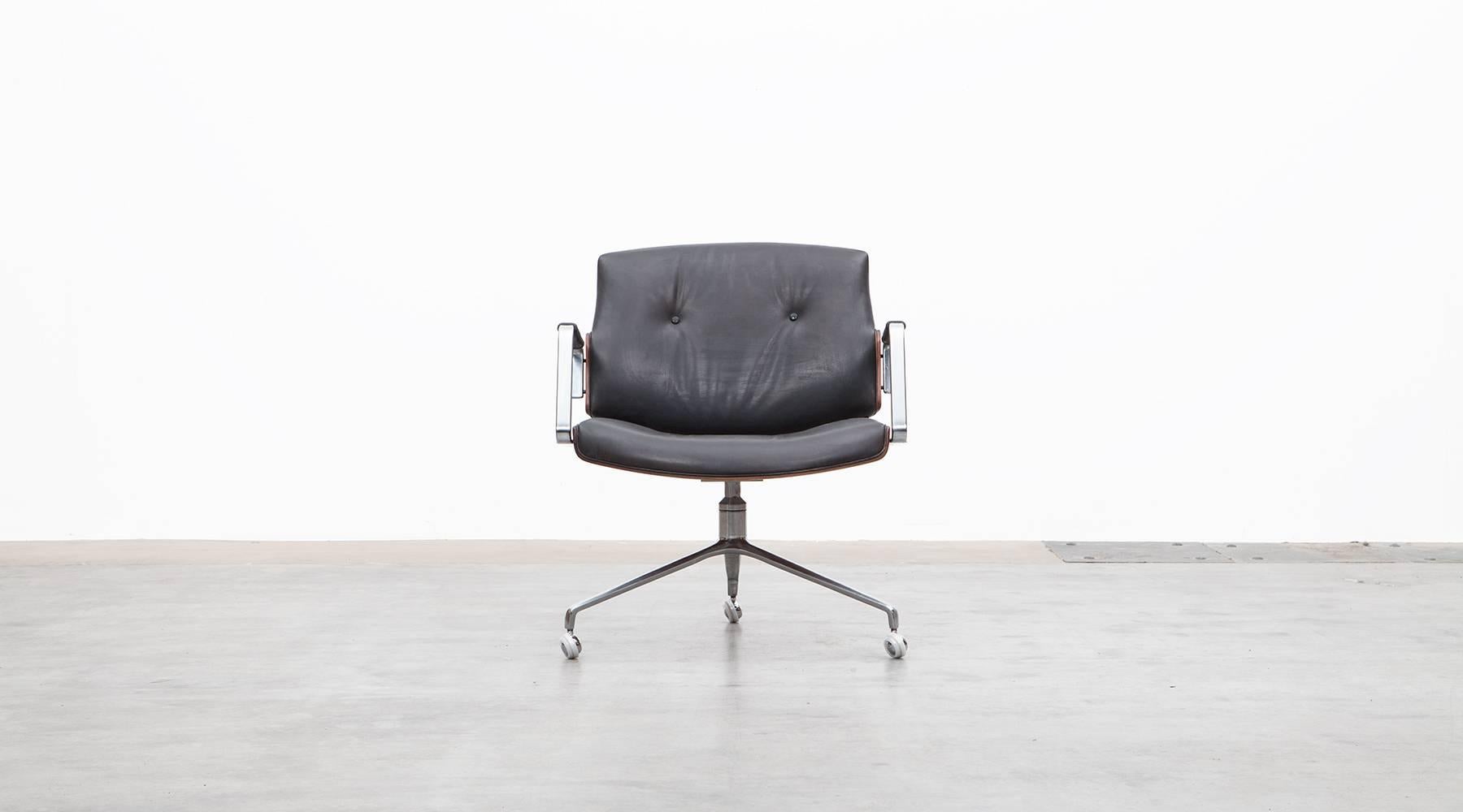 Classical swivel chairs designed by Preben Fabricius and Jørgen Kastholm. The chair has a brushed steel tripod foot, high quality leather upholstery and two curved wooden shells in rosewood. This model has slight signs of wear at the edges and light