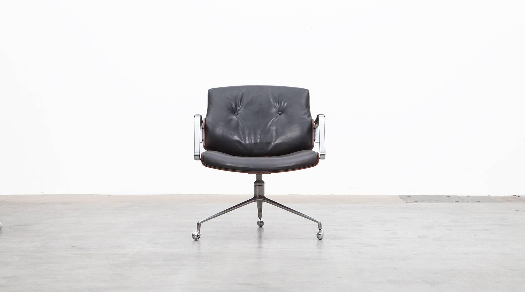 Classical swivel chairs designed by Preben Fabricius and Jørgen Kastholm. The chair has a brushed steel tripod foot, high quality leather upholstery and two curved wooden shells. This model has slight signs of wear in the wood which are rewired, the