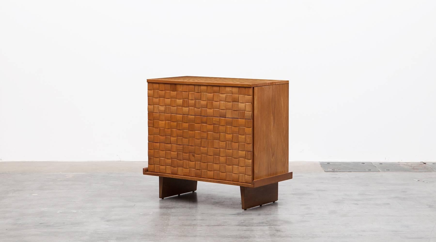 Handsome ash cabinet designed by Paul Laszlo features three of his basket weave drawer fronts and modern shaped legs. The sideboard comes in very good original condition. Manufactured by Brown Saltman.
