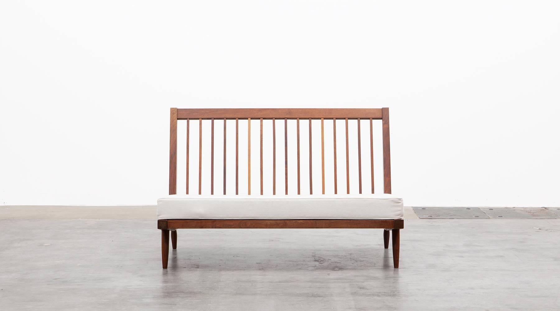 This beautiful and classical sofa designed by George Nakashima in walnut is having a deep cushioned seat angled for comfort and full back cushions. The wood of this piece is reworked and the cushions recently upholstered. This is a Classic and
