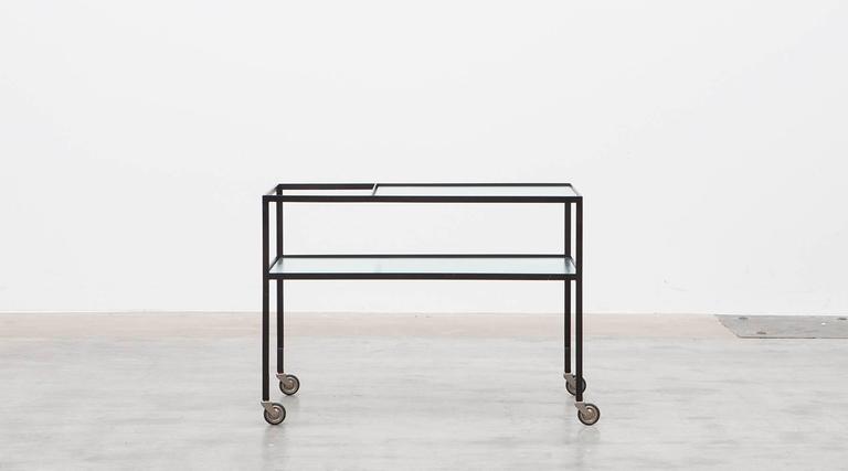 Slender Serving Cart in steel with original reeded glass plates is designed by German architect Herbert Hirche. The slender and reduced steel frame holds the very well-preserved original glass plate. Manufactured by Christian Holzäpfel KG. 

Bauhaus