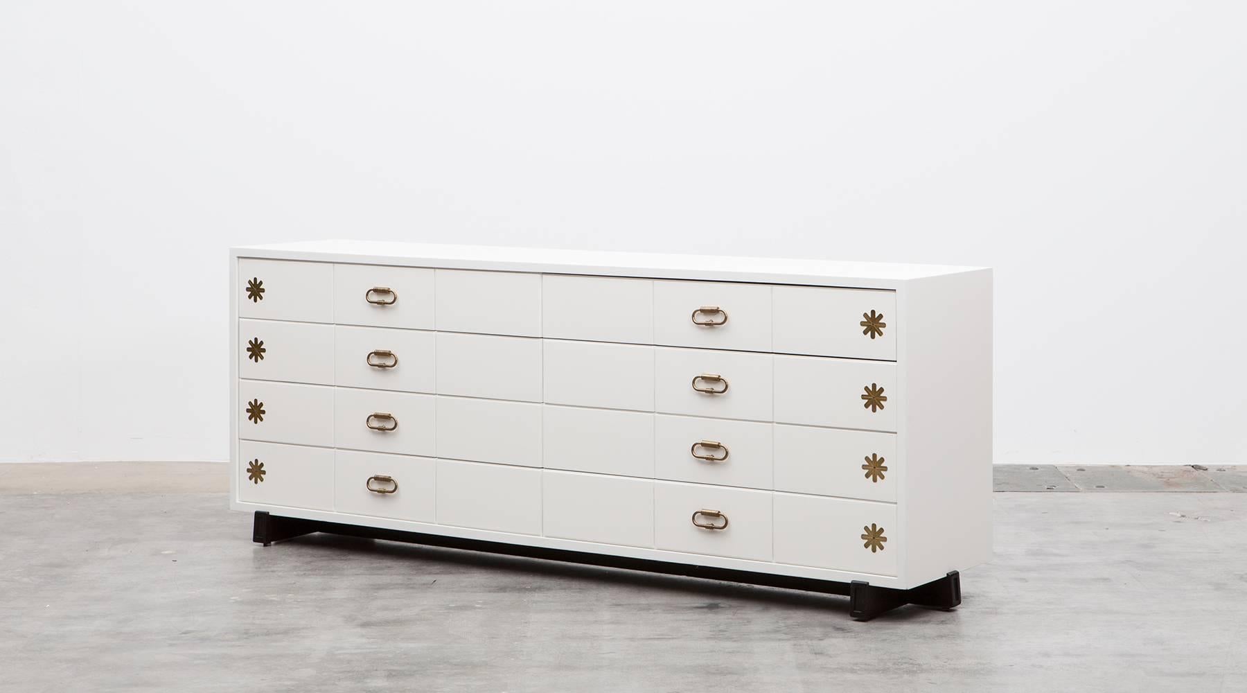 This fabulous eight-drawer sideboard designed by American Tommi Parzinger features a wooden corpus, lacquered in white, the frame is mahogany and the special handles and decorative details comes in brass. Simply one of the finest pieces by this
