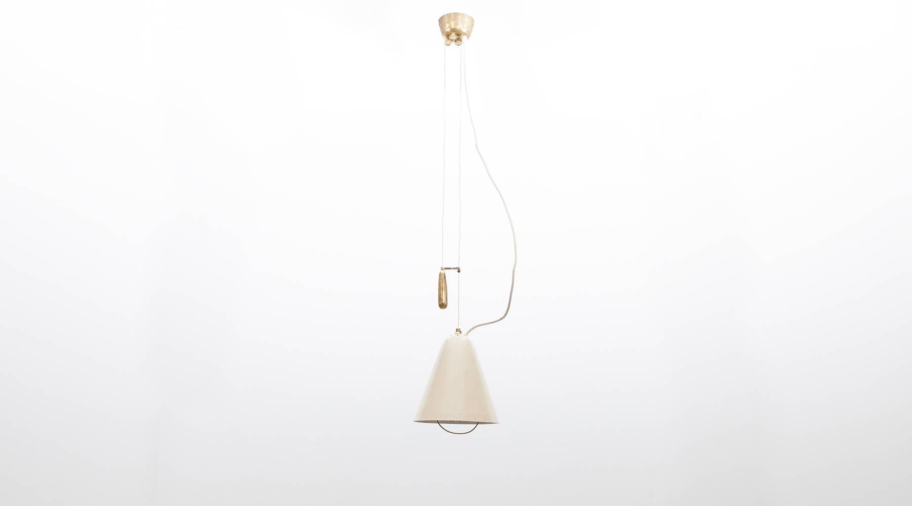 Very elegant counterweight pendant designed by famous Finnish Paavo Tynell in lacquered metal and brass details, giving a warm charming light with large brass balance, to change the height of this lamp. Manufactured by Taito Oy.
