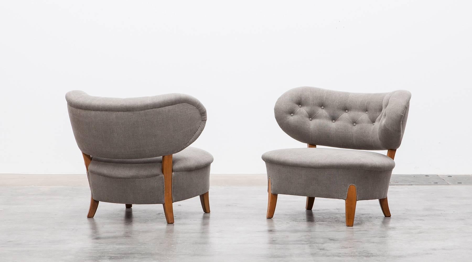 This beautiful pair of lounge chairs designed by Otto Schulz comes with a curved back decorated with buttons. Seat and back are newly upholstered, the frame and legs are made out of ash. Manufactured by Boet.
