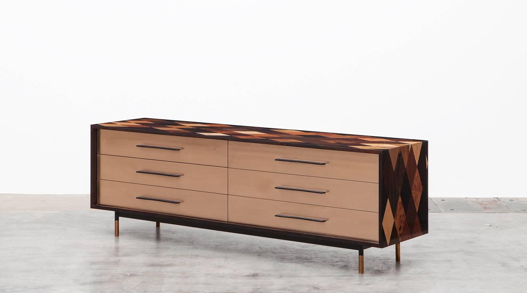 Sideboard by contemporary German artist Johannes Hock. The corpus comes in veneered tabletop in diamond pattern, used by 30 types of wood. The drawer front is bronze and contains six of it. Manufactured by Atelier Johannes Hock.

Hock learned