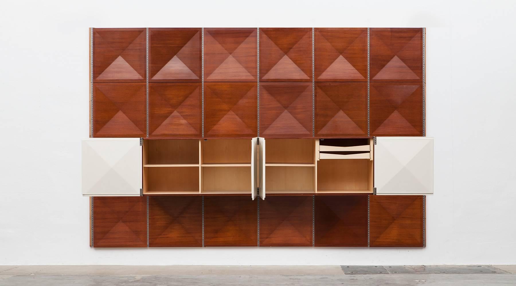 Very unique combination and rare to get. The panel wall consisting of 24 pieces comes in mahogany. Both, the sideboard with four white lacquered diamond shaped doors and the panel wall are designed by Antoine Philippon and Jacqueline Lecoq. The