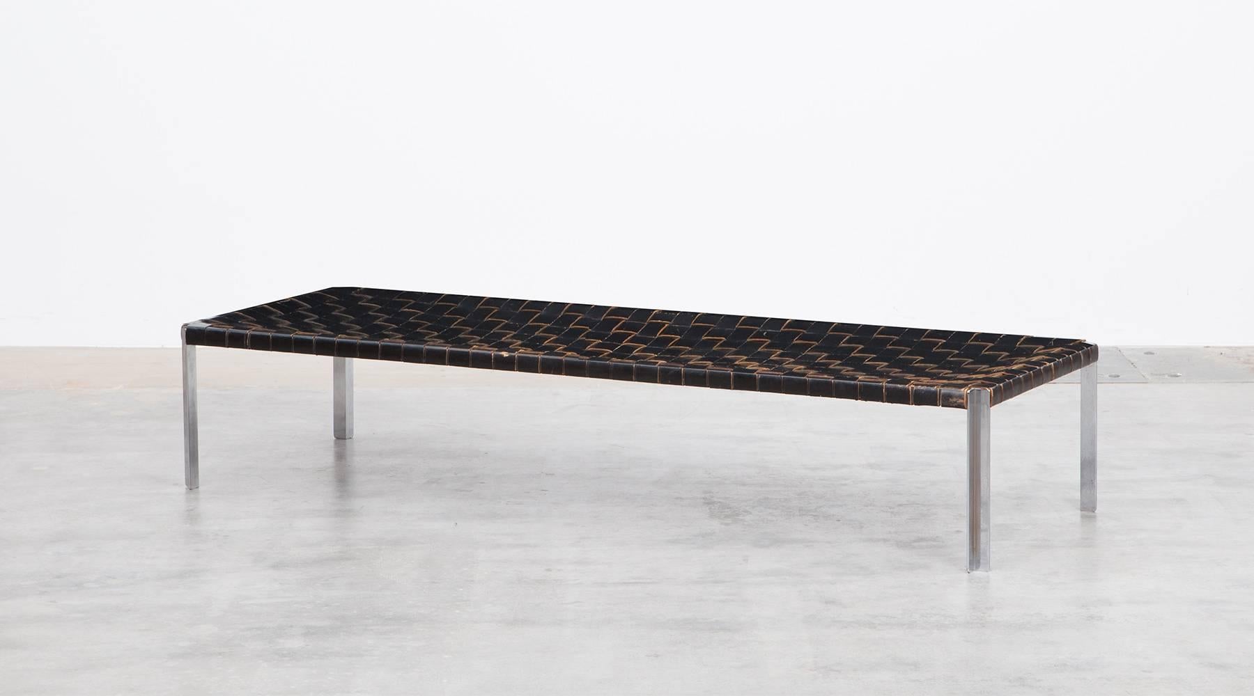 Magnificent bench with woven leather belts in black on a matte chromium plated steel base. The confident, clear-shaped bench is an original example from 1955, manufactured by Laverne International. 

The designer couple Erwine and Estelle Laverne,