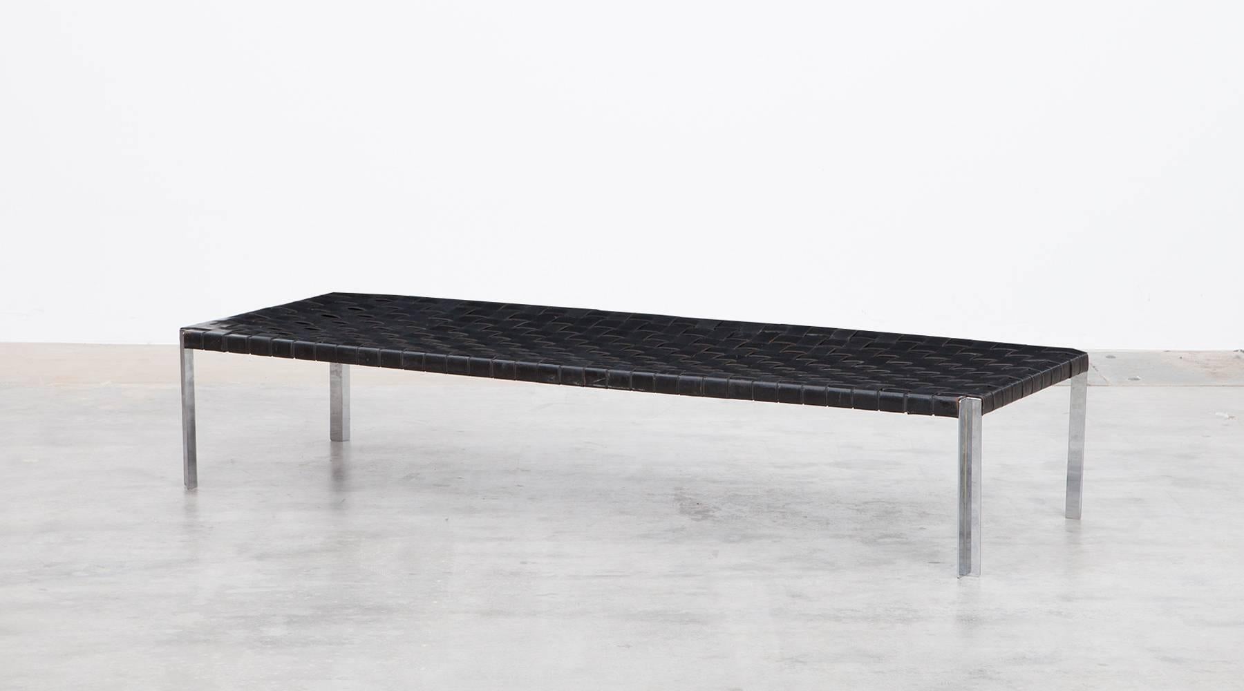 Magnificent bench with woven leather belts in black on a matte chromium plated steel base. The confident, clear-shaped bench is an original example from 1955, manufactured by Laverne International. 

The designer couple Erwine and Estelle Laverne,
