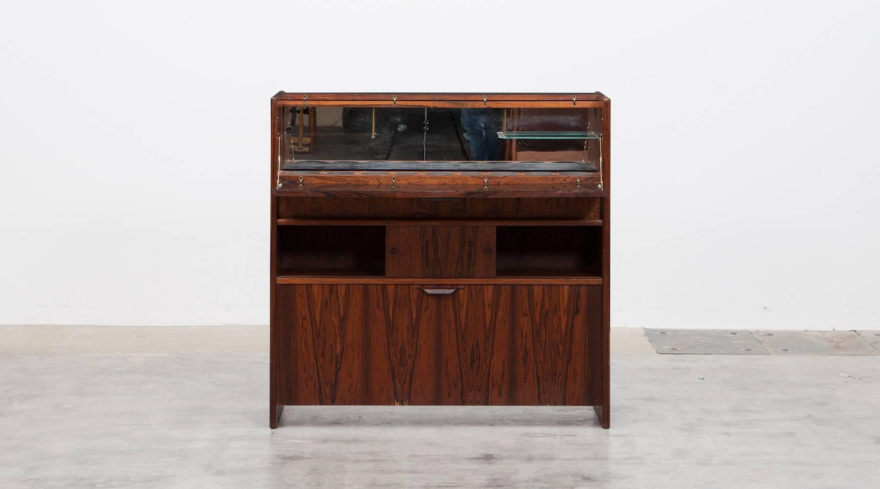 This wonderful little rosewood bar is designed by Johannes Andersen. An amazing angular, 1960s bar in solid rosewood. Wide enough accommodate two bar-stools, the front features a brass foot-rail. In excellent original conditions, this bar is