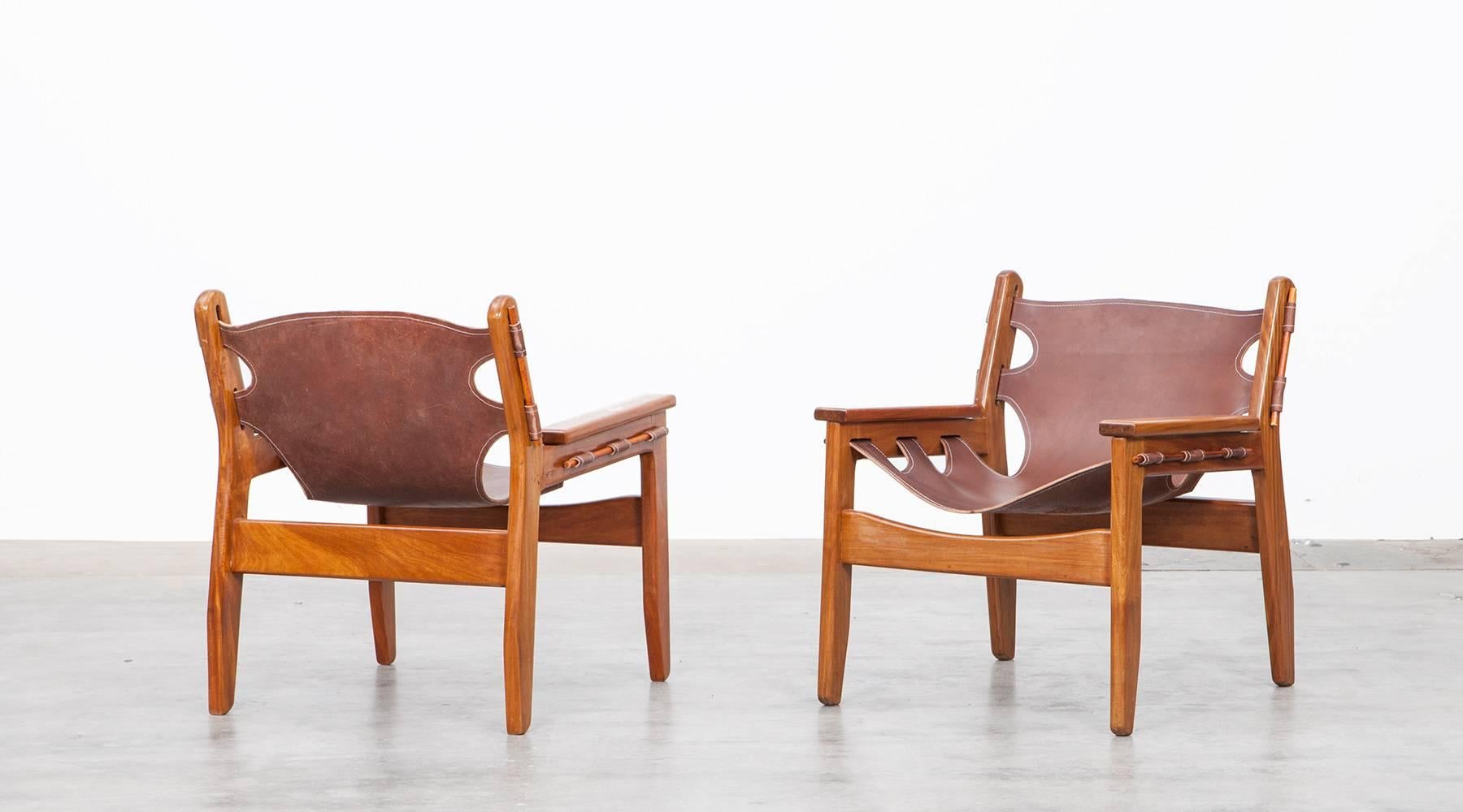 Beautiful Brazilian solid  wooden and leather Kilin lounge chairs designed by Sergio Rodrigues in 1973. The original and nicely aged leather sling seat has a great patina and looks beautiful in contrast with the warm wooden frame. The frames are in