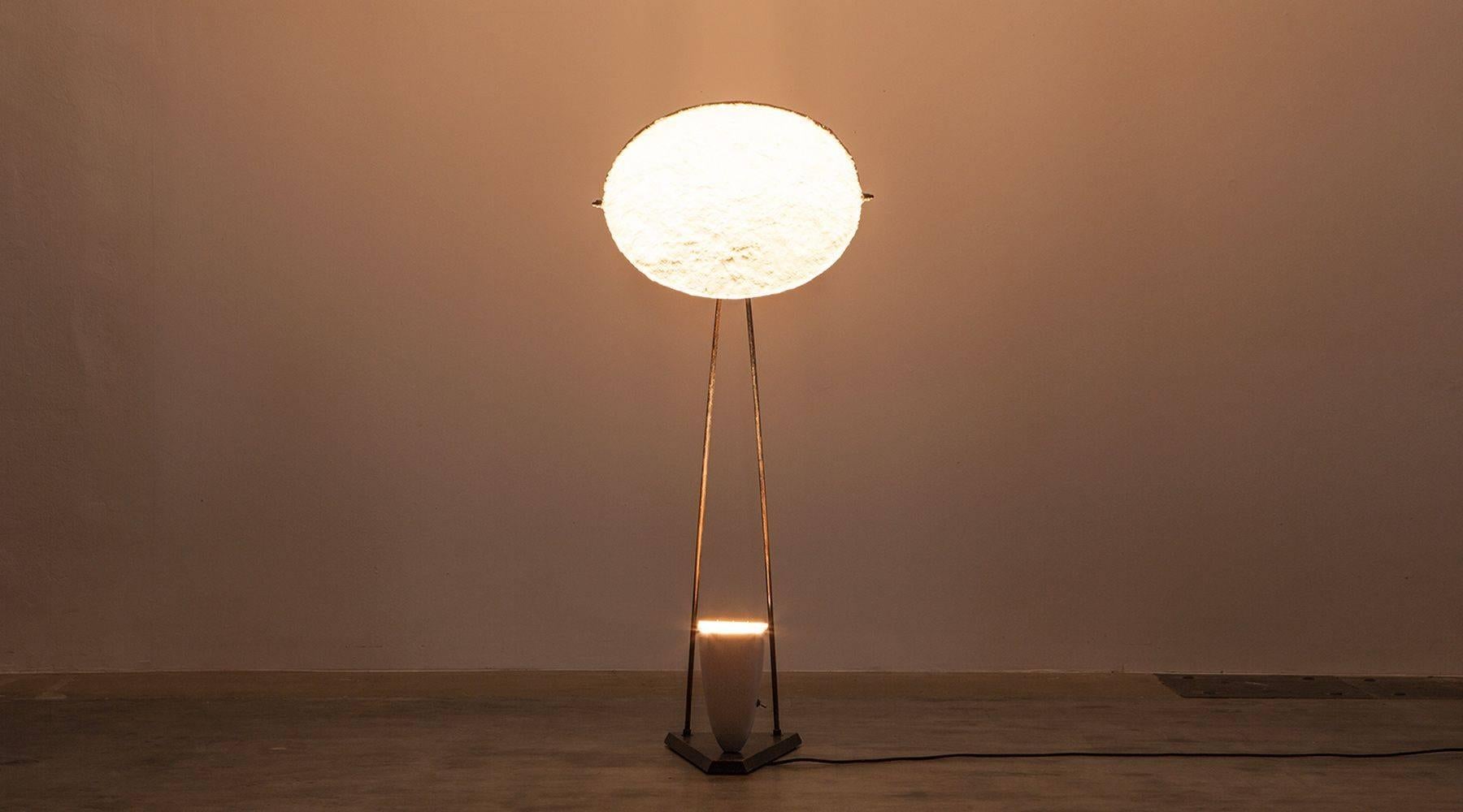 The marvellous 1950s floor lamp with a nicely structured ceramic shade in white on black lacquered wooden base comes with a large fiberglass diffuser that creates a gentle, indirect light. Its sculpturral character makes it a very exceptional piece.