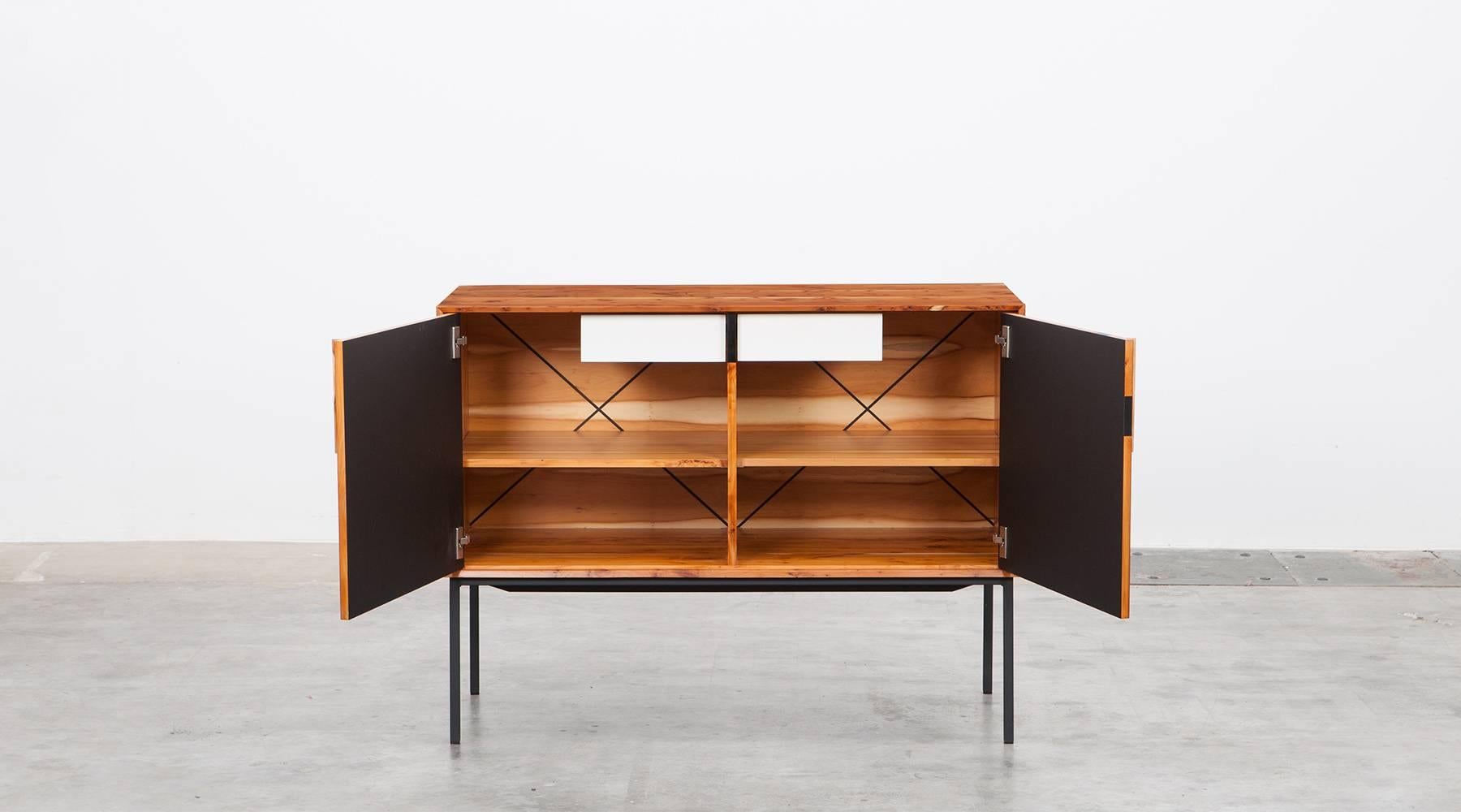 Sideboard by contemporary German artist Johannes Hock. The front of the doors this unique piece comes in black HPL, the corpus is made of high-quality solid yew on black metal legs. Manufactured by Atelier Johannes Hock. 

Hock refined his craft
