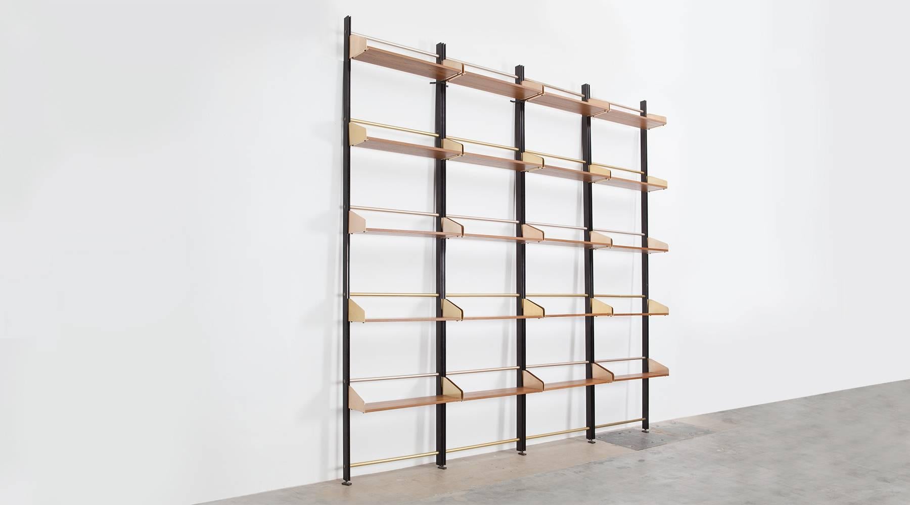 Elegant library with teak panels, brass and black lacquered metal stems devided in four sections. Shelves can be adjusted or put in different positions. As shown on the pictures the metal details appears in two different shades, which do not