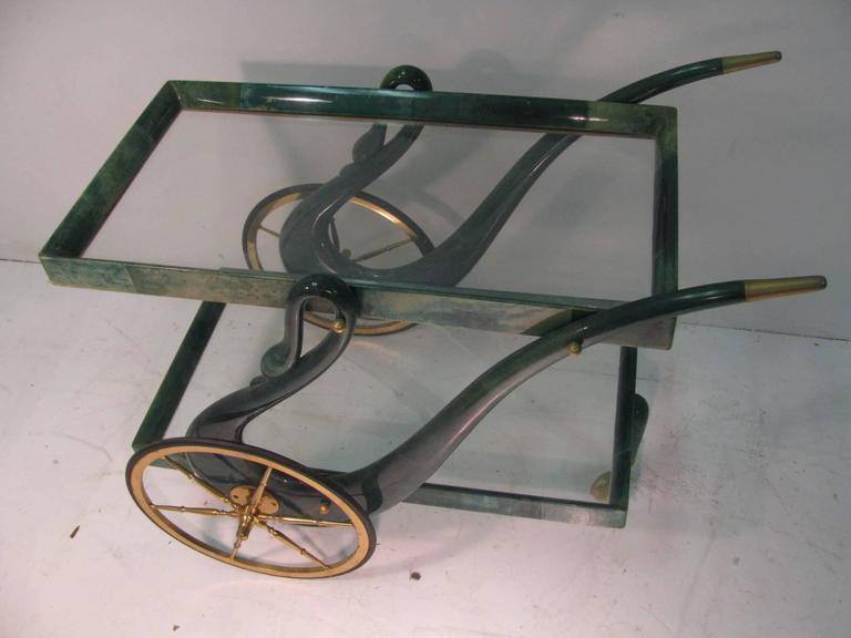 Fabulous lacquered goatskin bar cart by Aldo Tura. Swan form with two glass shelf. Solid brass fittings and components.