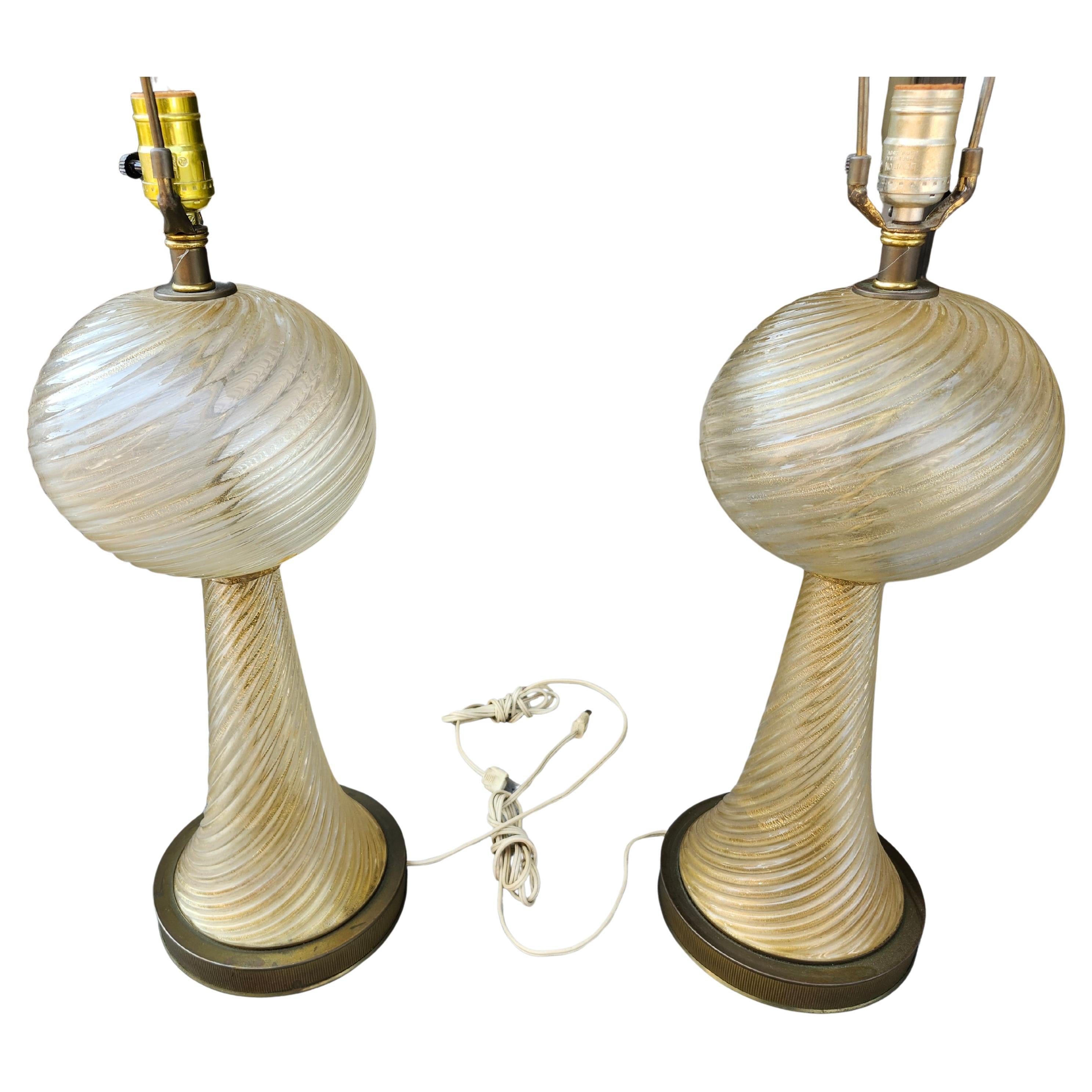 Fabulous pair of Murano Barovier & Toso hand blown table lamps. Swirl pattern on both top and bottom sections of the glass. Gold flecks throughout. Glass sits on a ribbed brass plinth base. Included at no extra cost are a pair of Hilo Steiner hand