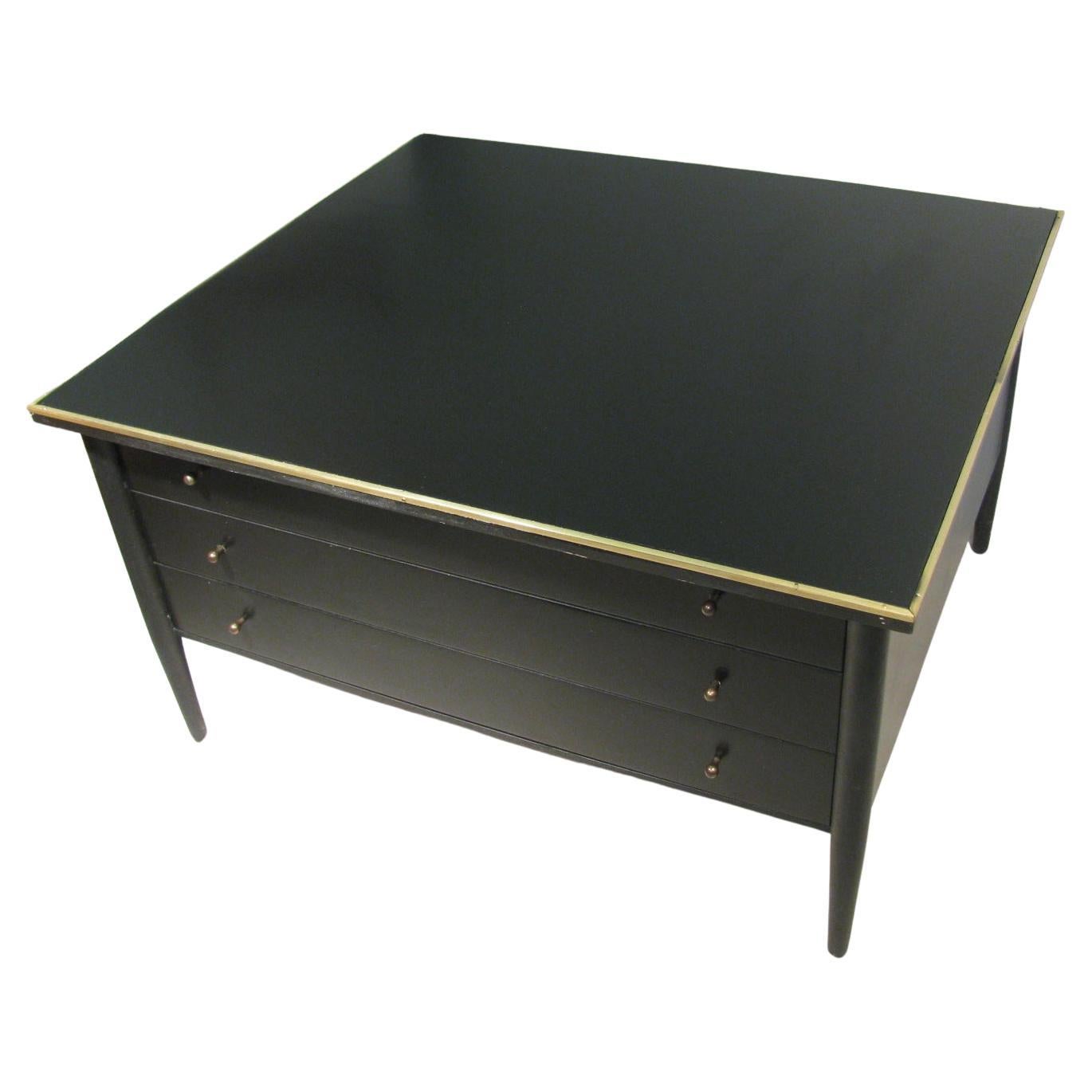 Paul McCobb Connoisseur collection for H. Sacks and Sons, Brookline mass. Three-drawer cocktail table or large end table in black lacquer. Top is framed in brass along with bronzed drawer pulls. A very elegant piece in excellent vintage condition